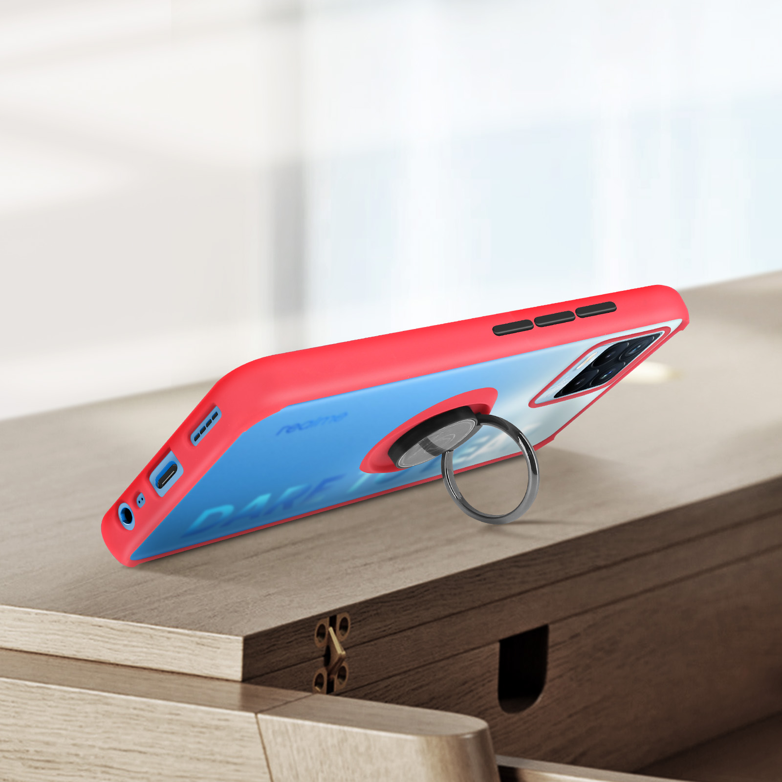 Custodia per telefono rossa e blu con supporto ad anello su superficie in legno.