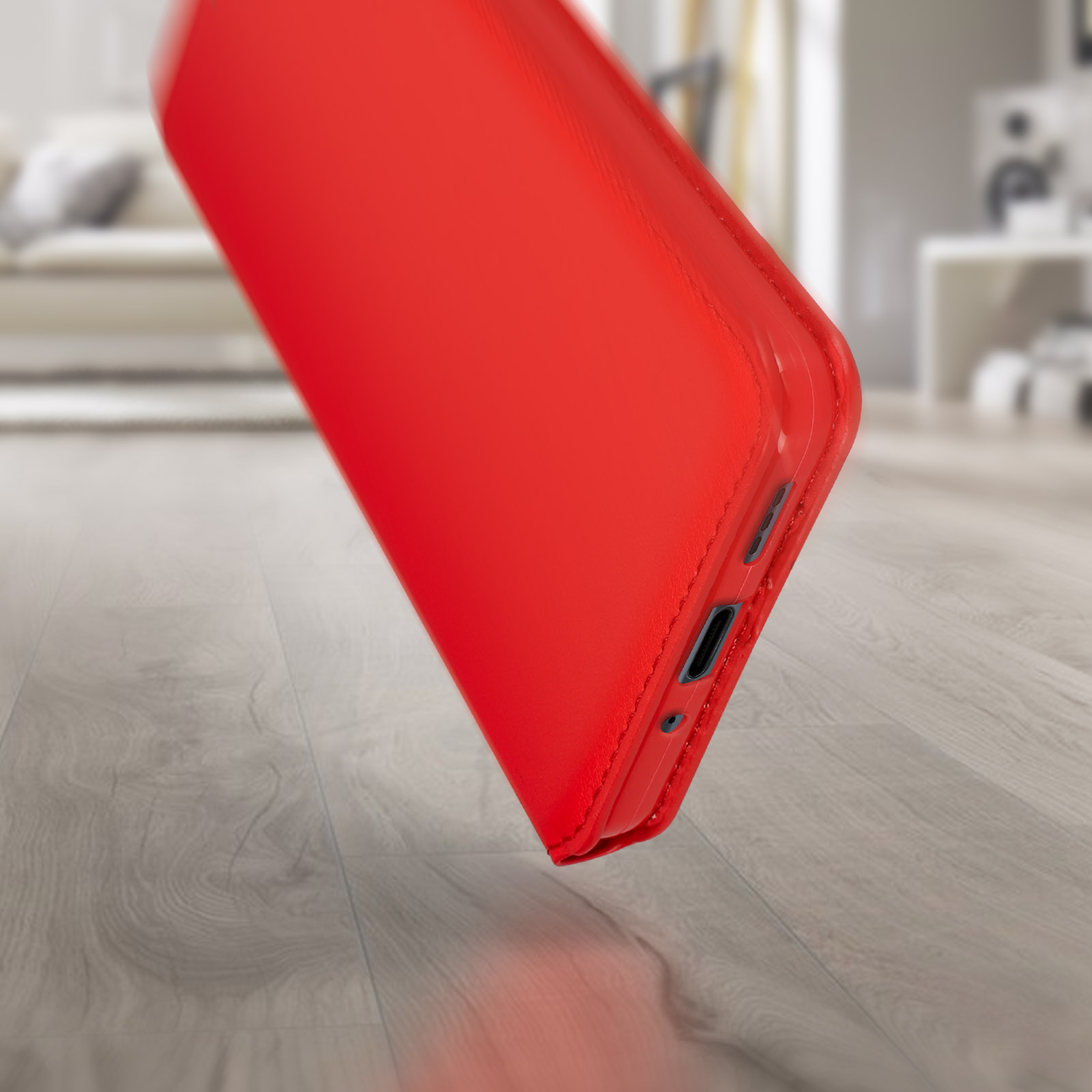 Una custodia per telefono rossa su un pavimento in legno, leggermente angolata.