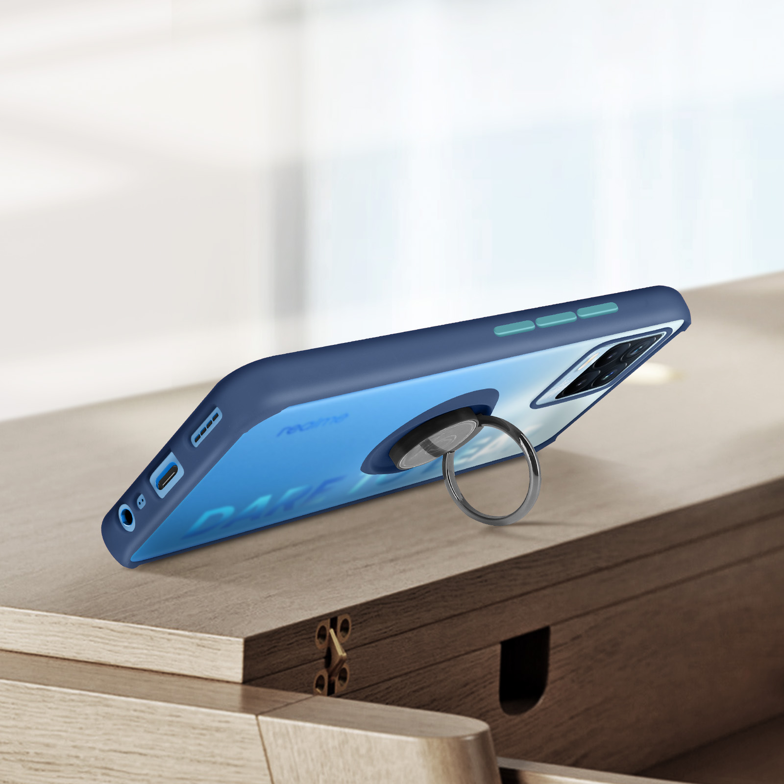 Una custodia per telefono blu con un supporto ad anello argentato su un tavolo di legno. Il telefono ha una sfumatura blu.