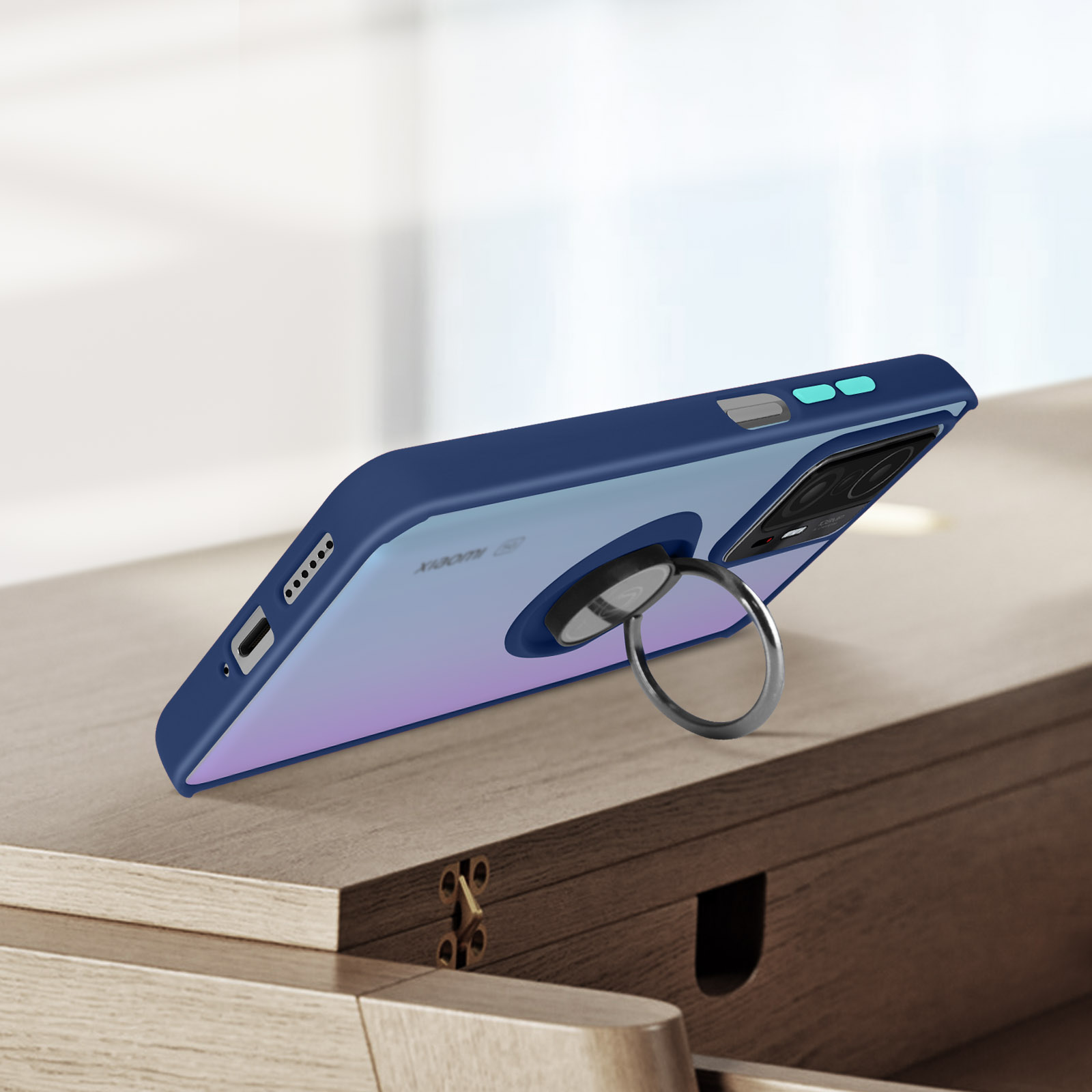 Una custodia per telefono blu con un portaanello è su una superficie di legno. La fotocamera del telefono è visibile.