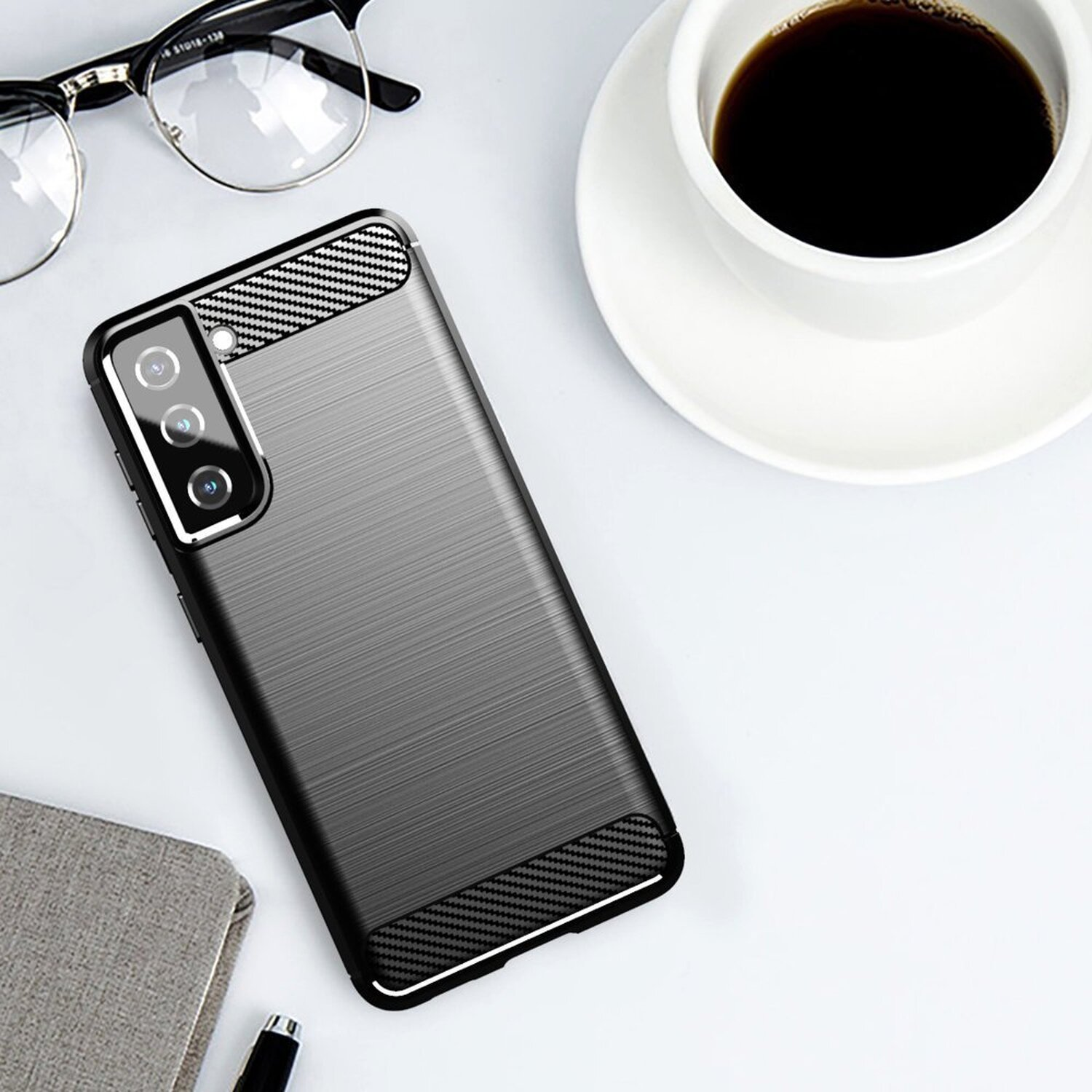 Eine Handyhülle auf einem Schreibtisch mit Brille und einer Tasse Kaffee.