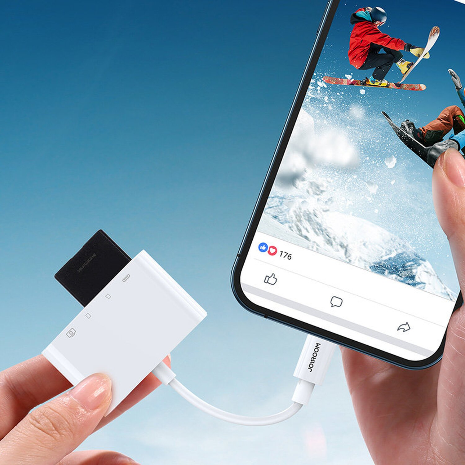 Weißer Kartenleser, der mit einem Telefon verbunden ist, das einen Social-Media-Beitrag mit Skifahrern zeigt. Blauer Hintergrund.