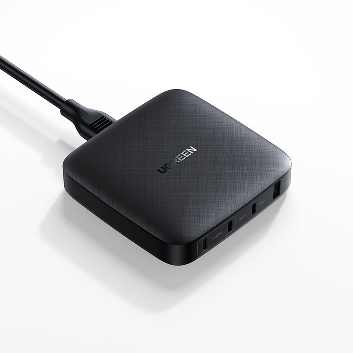 Ein schwarzes UGREEN-Netzteil mit mehreren Anschlüssen und einem Kabel auf weißem Hintergrund.
