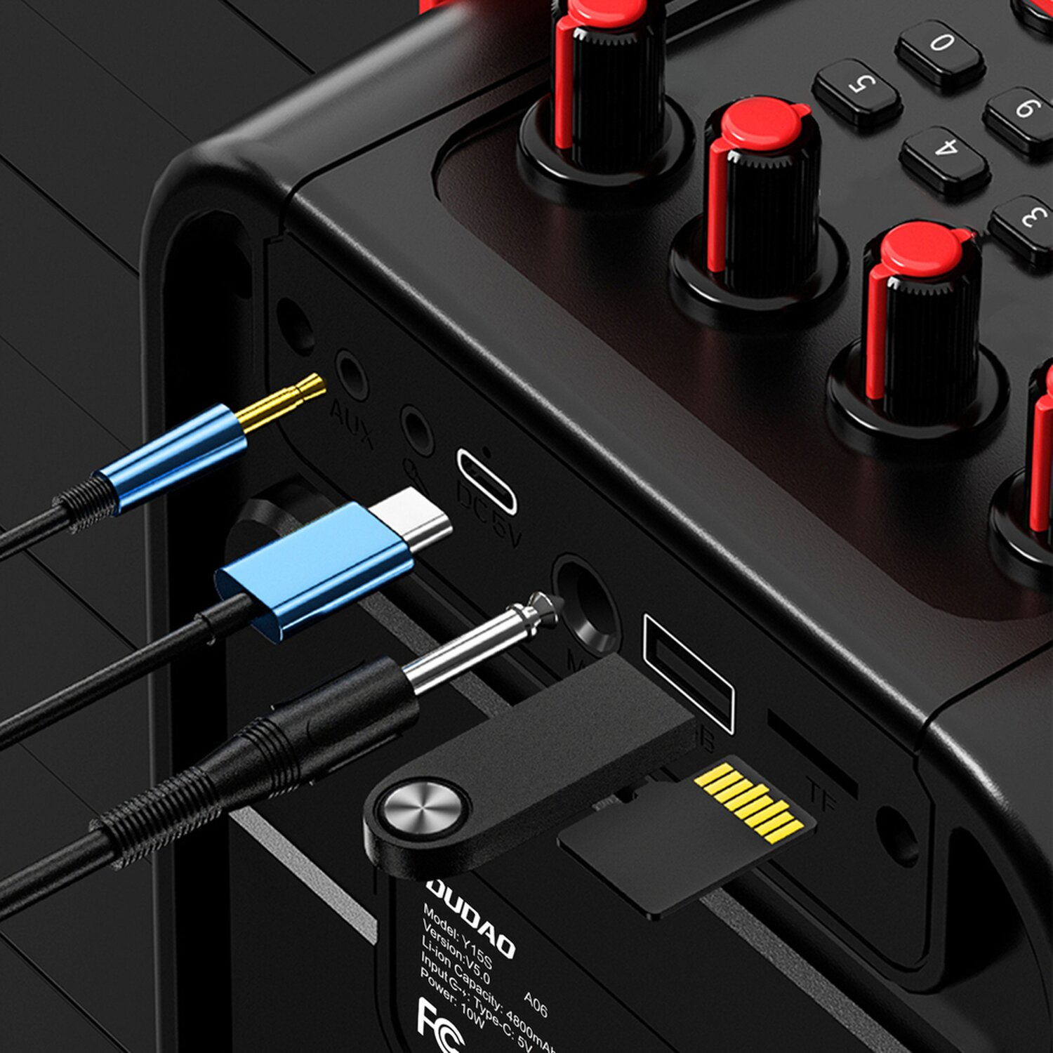 Schwarzes Audiogerät mit eingesteckten Kabeln. USB, AUX und SD-Kartensteckplätze sind sichtbar.