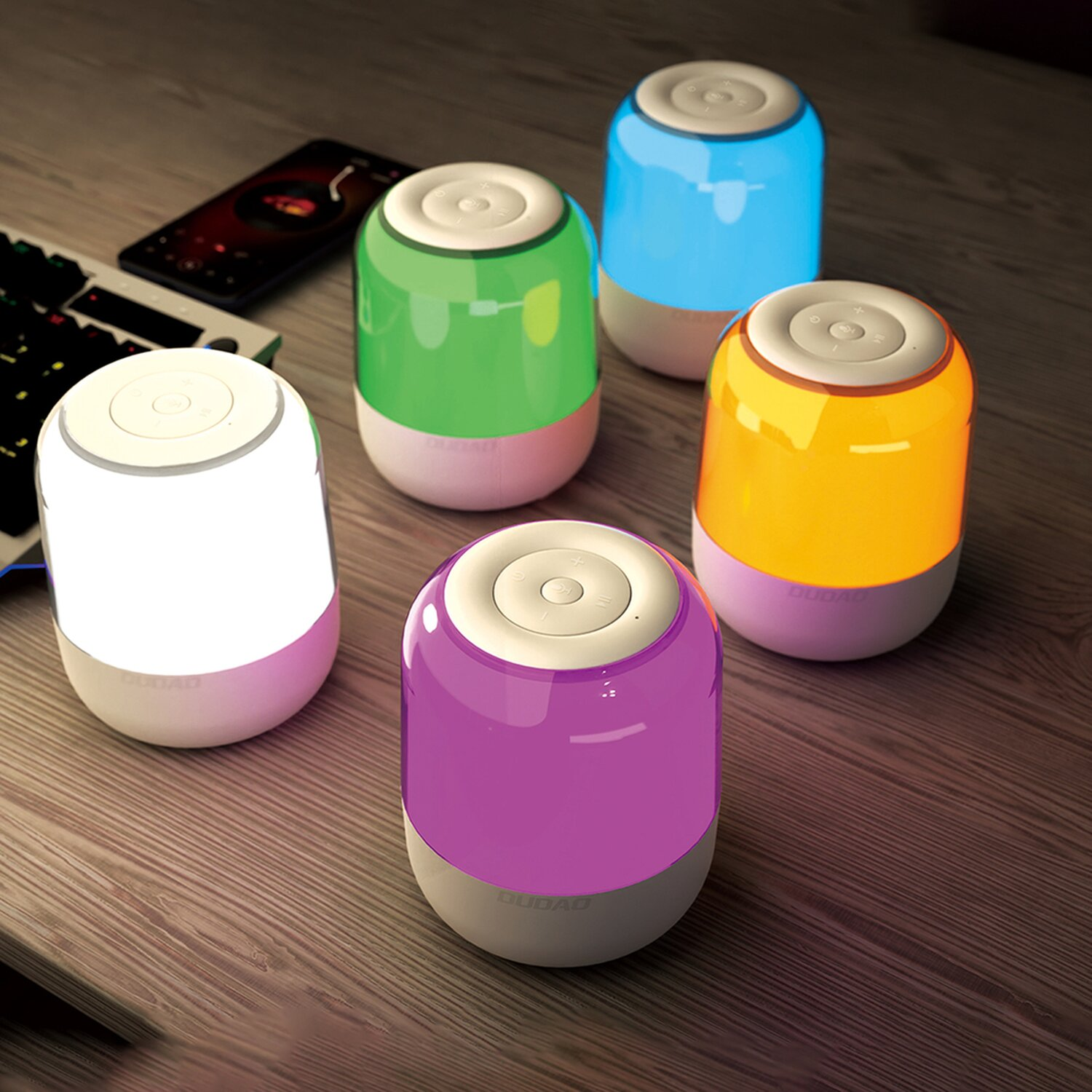 Fünf farbige Touch-Lampen auf einer Holzoberfläche, mit Smartphone und Tastatur im Hintergrund.
