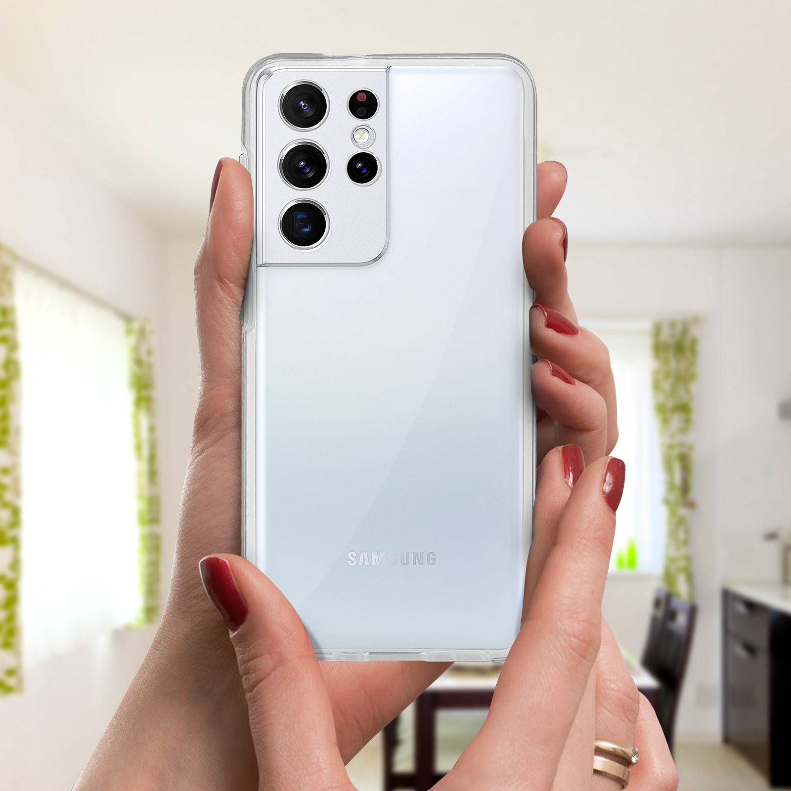 Persona che tiene in mano un telefono con più fotocamere. Il telefono è in una custodia trasparente. Lo sfondo è sfocato.