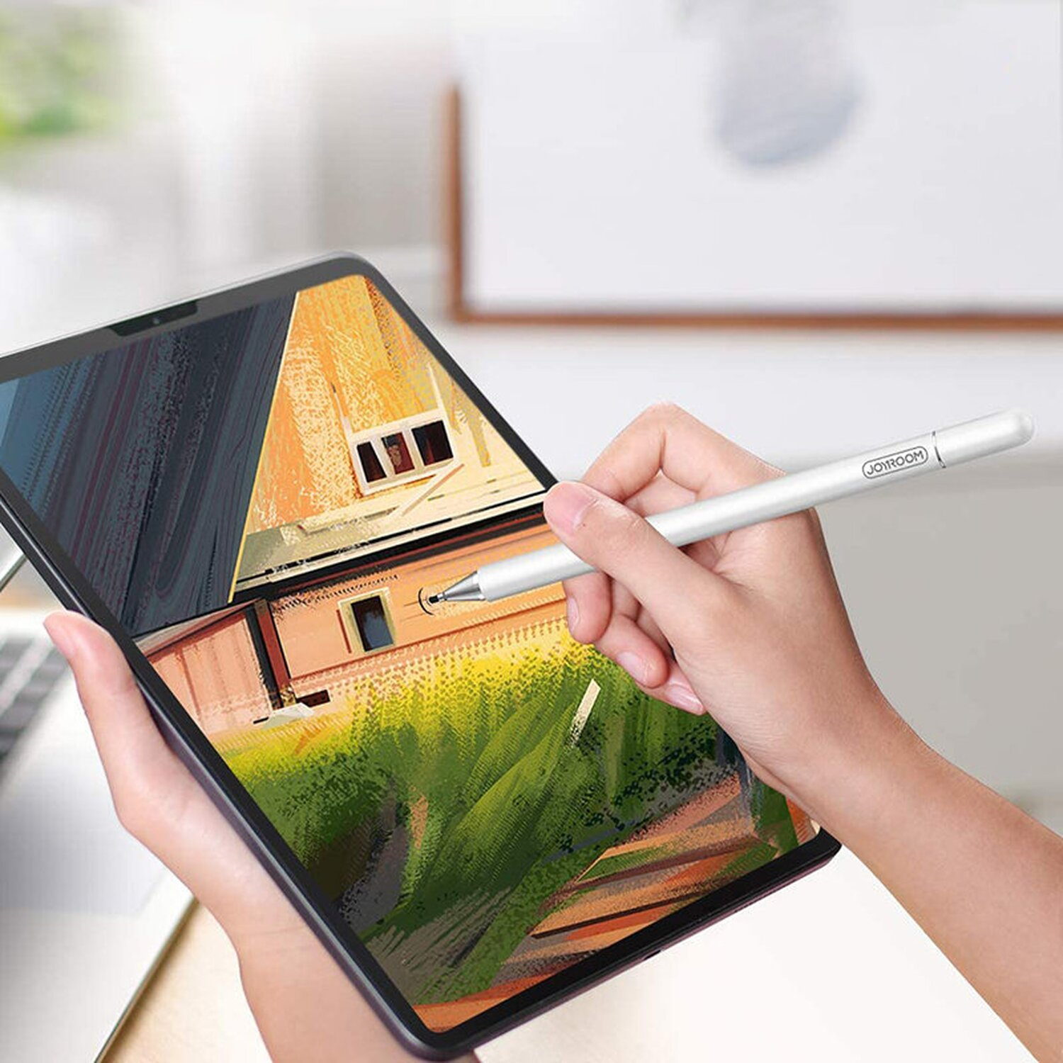 Hand, die einen silbernen Stift über einem Tablet hält. Der Tablett-Bildschirm zeigt ein Haus.