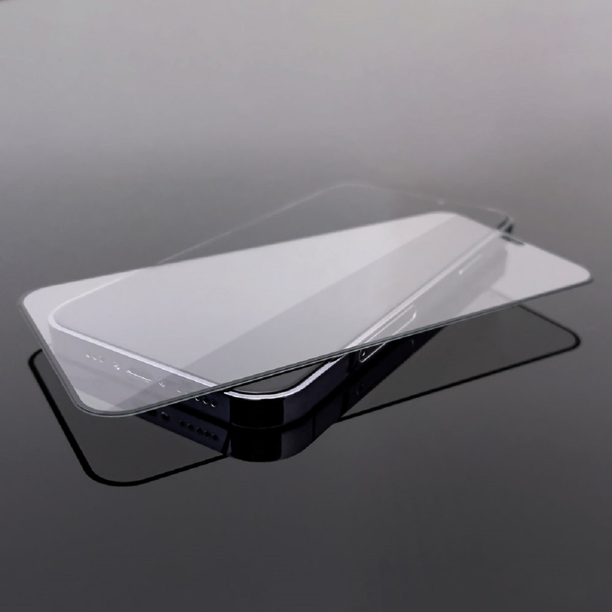 Zwei Glasschutzfolien auf schwarzer Oberfläche, Licht reflektierend.