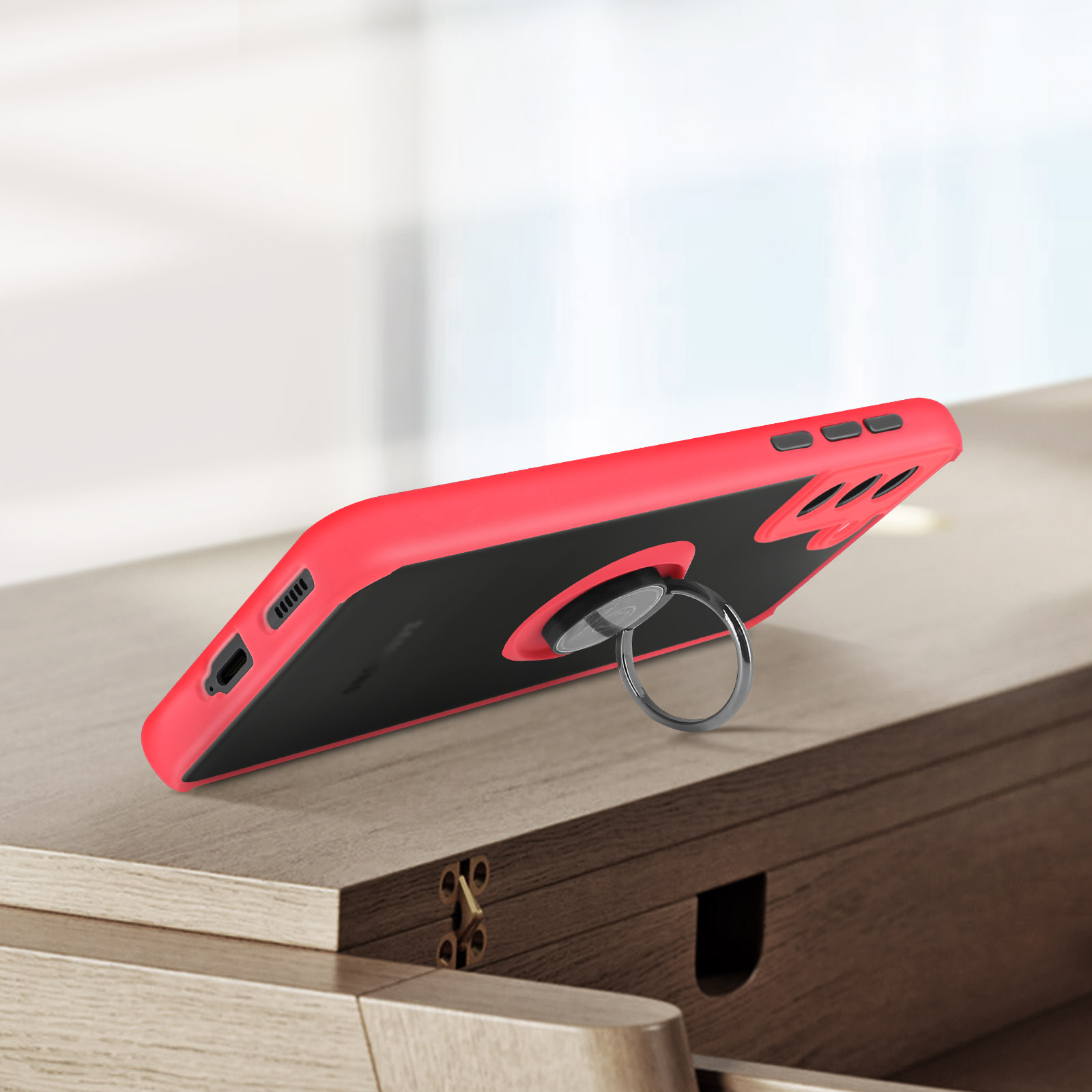 Une coque de téléphone rouge avec support d'anneau sur une surface en bois. Fond flou.
