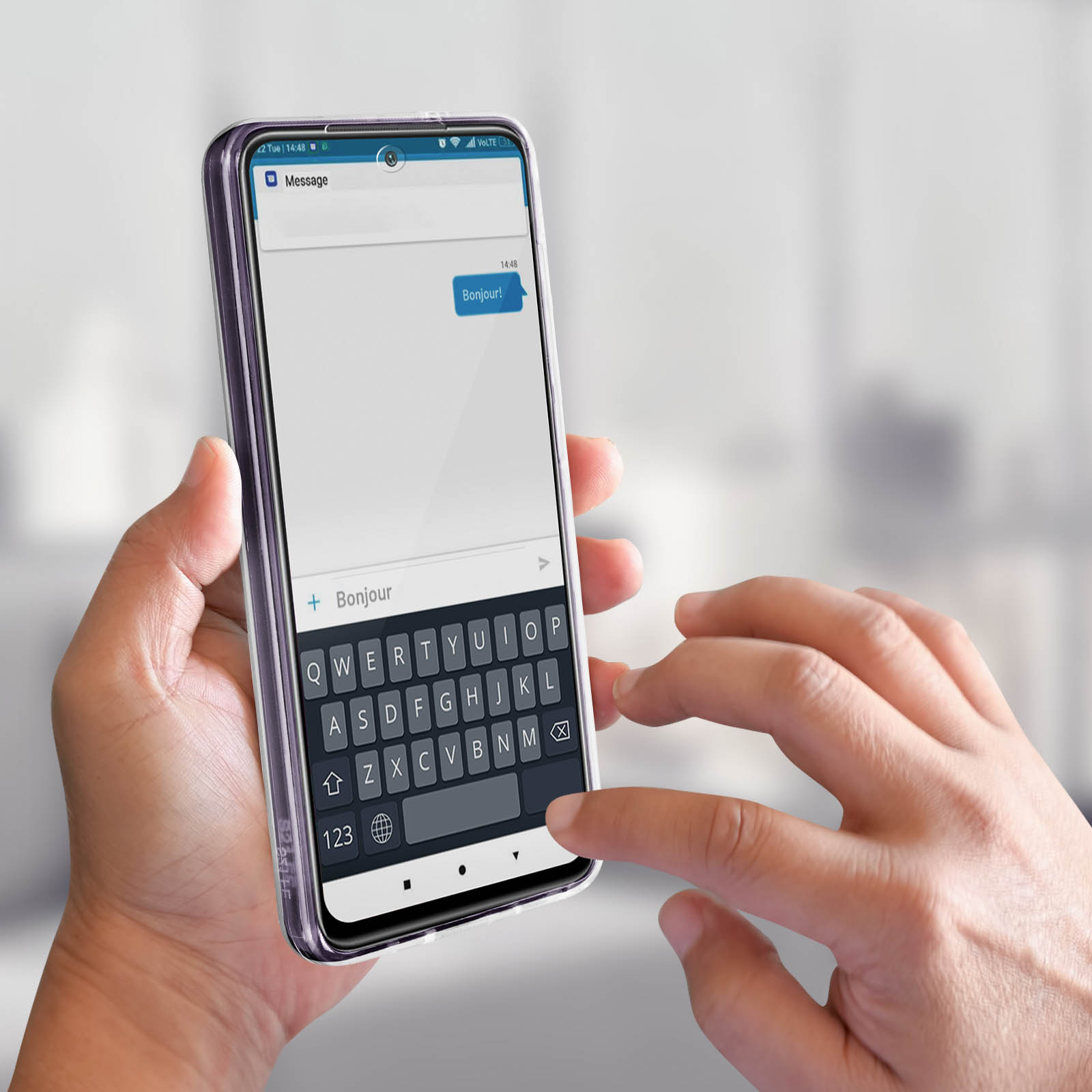 Mano che tiene un telefono. Il telefono mostra un messaggio di testo, la tastiera è aperta per la digitazione. Sfondo sfocato.