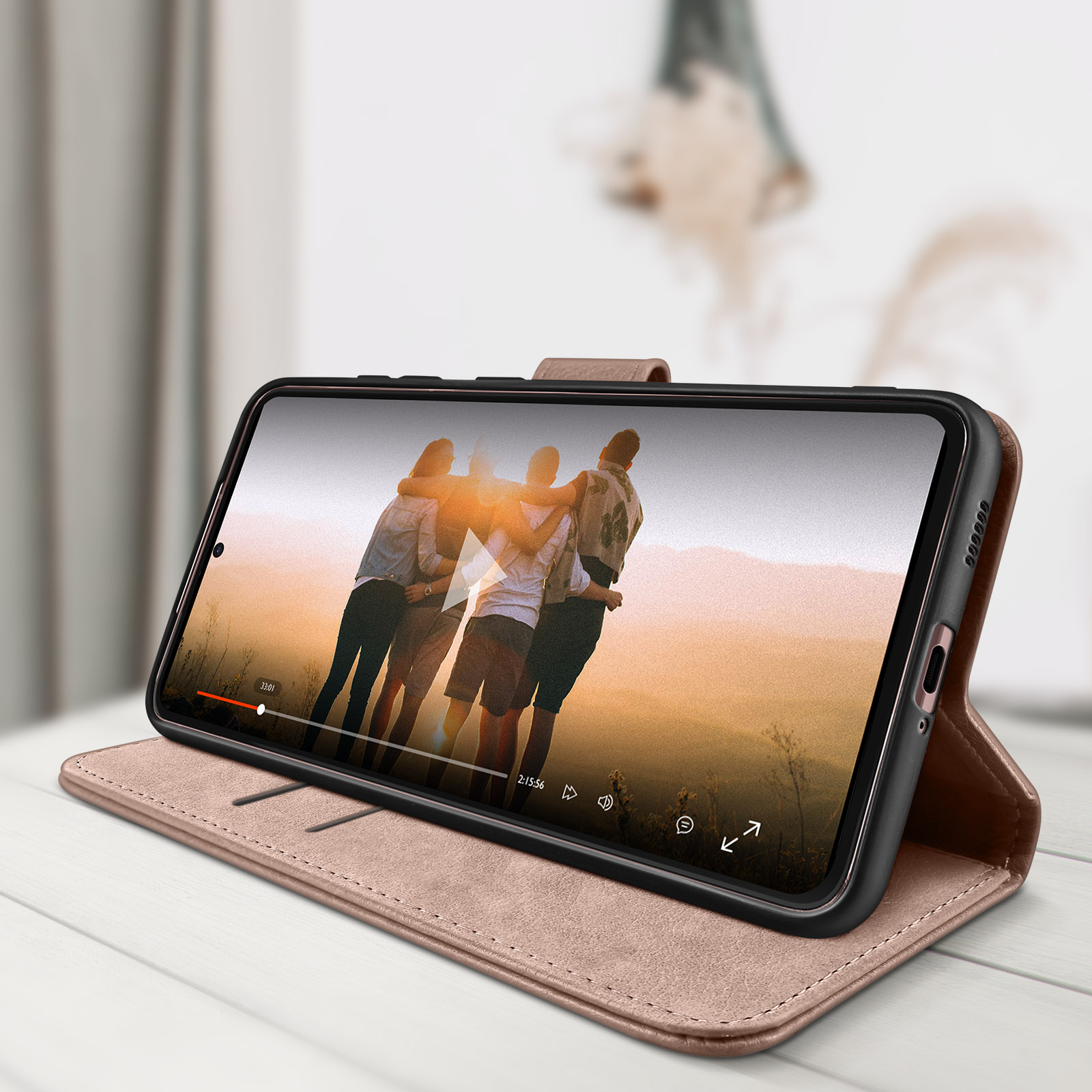 Téléphone dans un étui marron lisant une vidéo de personnes. L'étui est sur une surface en bois.