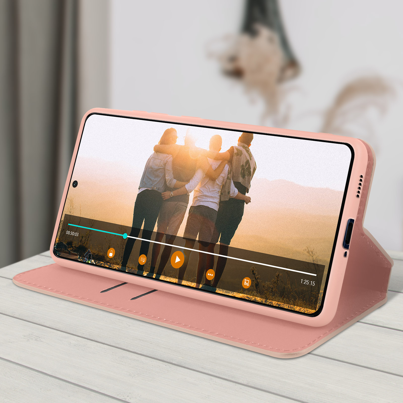 Una custodia rosa per telefono che tiene un telefono che riproduce un video. Le persone sono sullo schermo.