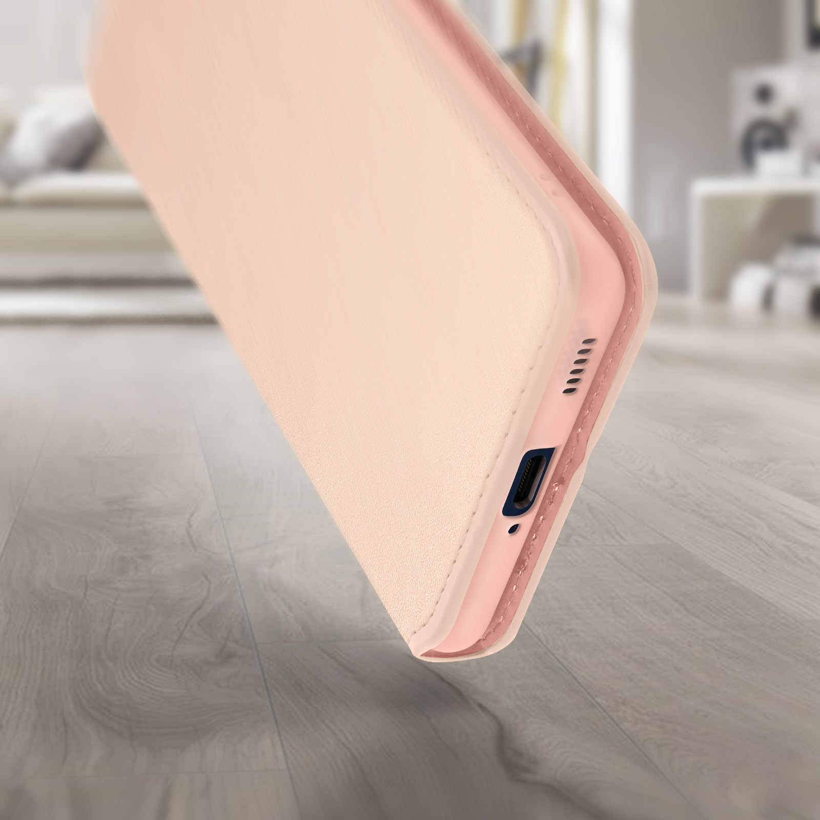 Una custodia per telefono in rosa, che mostra il lato del telefono. Lo sfondo è una superficie in legno.