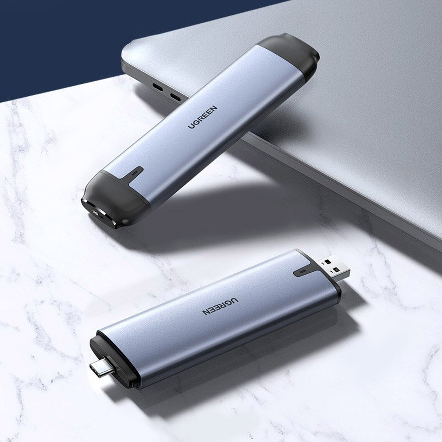 Zwei silberne UGREEN USB-Geräte. Eines hat USB-A, das andere USB-C. Beide auf hellem Untergrund.