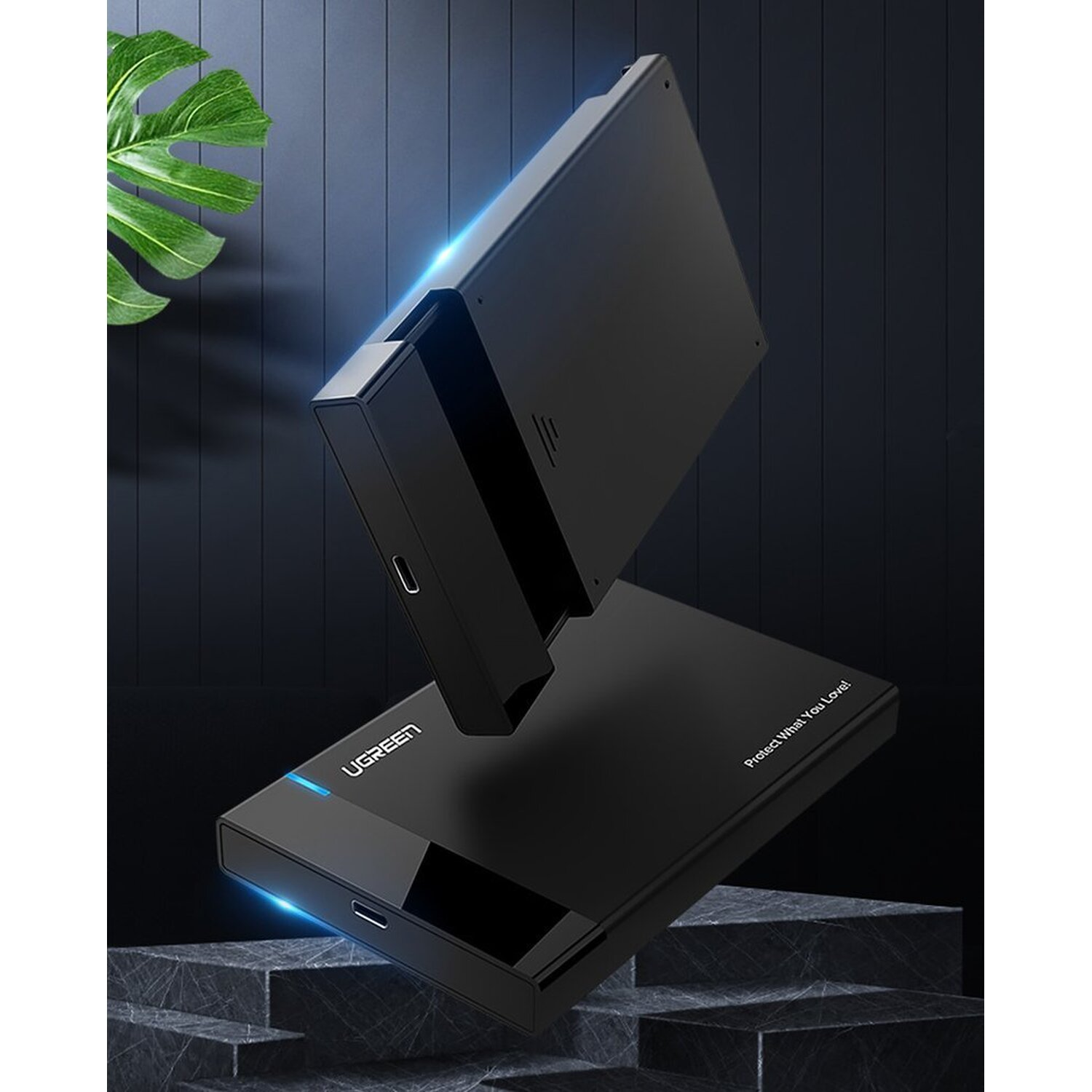 Czarny zewnętrzny dysk twardy na ciemnej powierzchni. Drugi dysk twardy w tle.