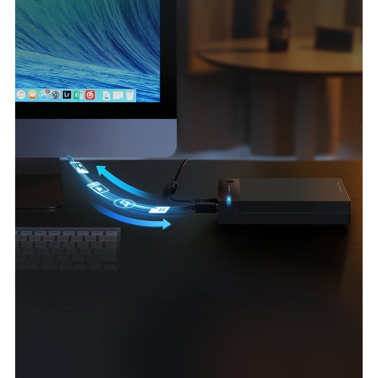 Schwarzer Schreibtisch mit Monitor, Tastatur und externer Festplatte. Blaue Pfeile zeigen Datentransfer.