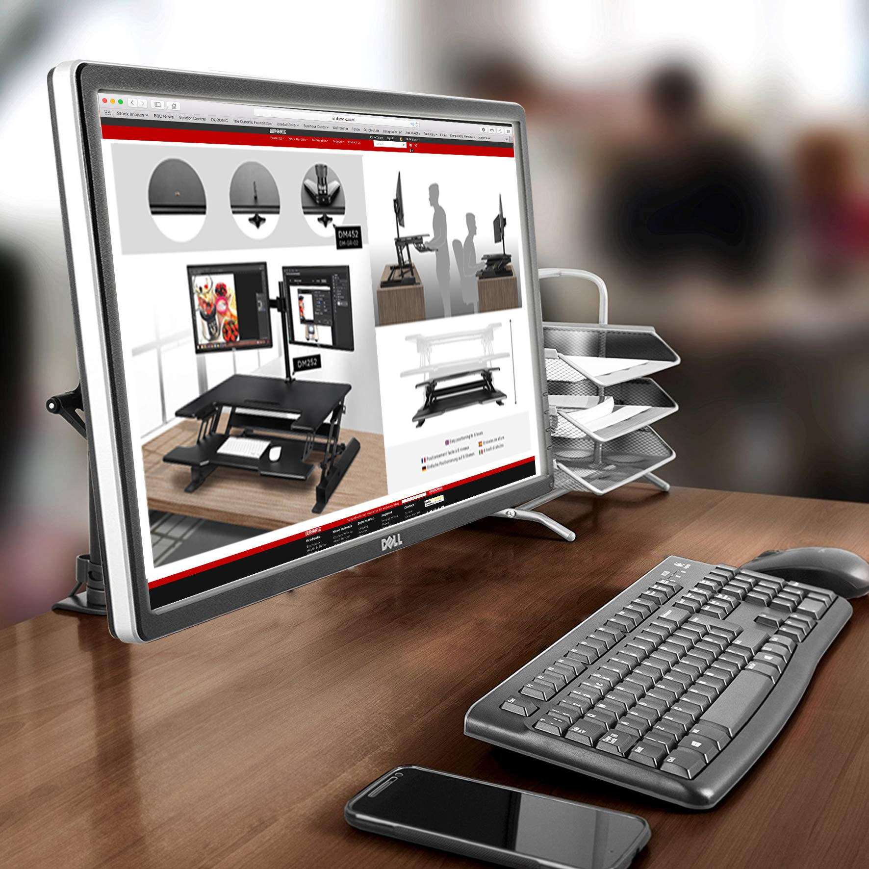 Computereinrichtung mit Monitor, Tastatur, Maus und Telefon. Der Monitor zeigt eine Website.