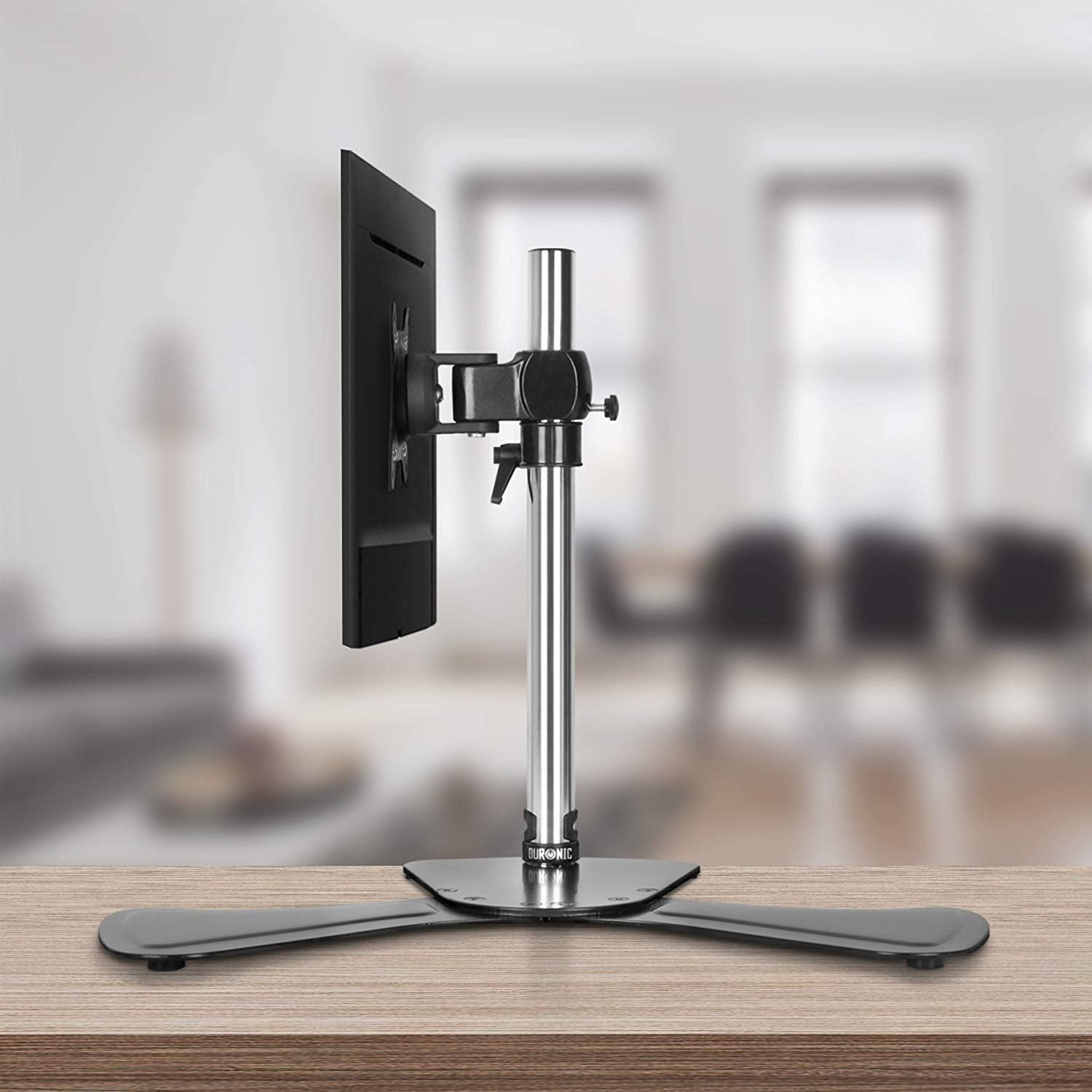 Soporte de monitor. La base es ancha y plana. El monitor está sujeto al soporte.