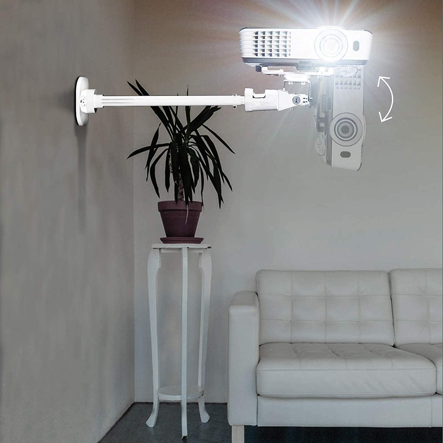 Proyector montado en la pared, con planta y sofá. Colores blanco y gris.