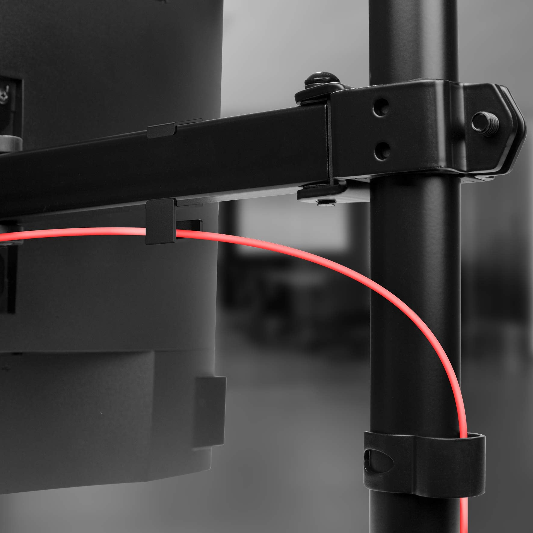 Soporte metálico negro y cable rojo en un soporte negro, en un entorno interior.