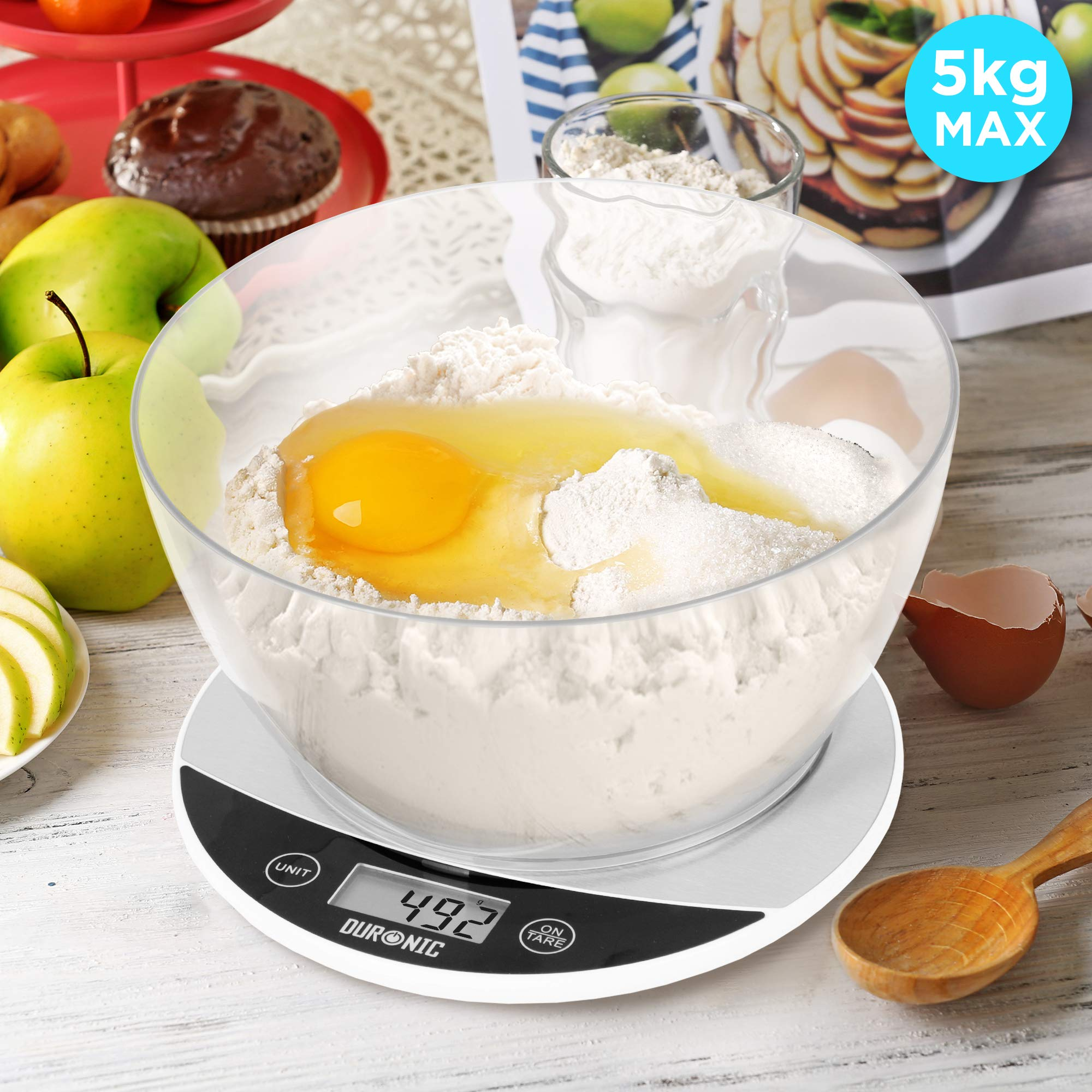 Eine Schüssel mit Mehl, einem Ei und anderen Zutaten auf einer Küchenwaage, mit einem 5kg Max-Etikett.