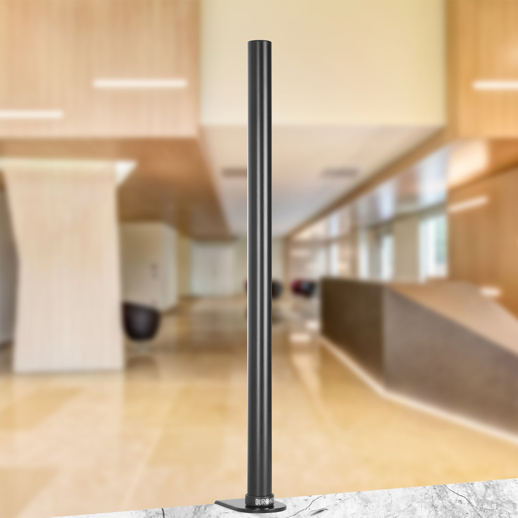 Eine schwarze, hohe Metallsäule in einem Büro. Die Säule steht auf einer marmorähnlichen Oberfläche.