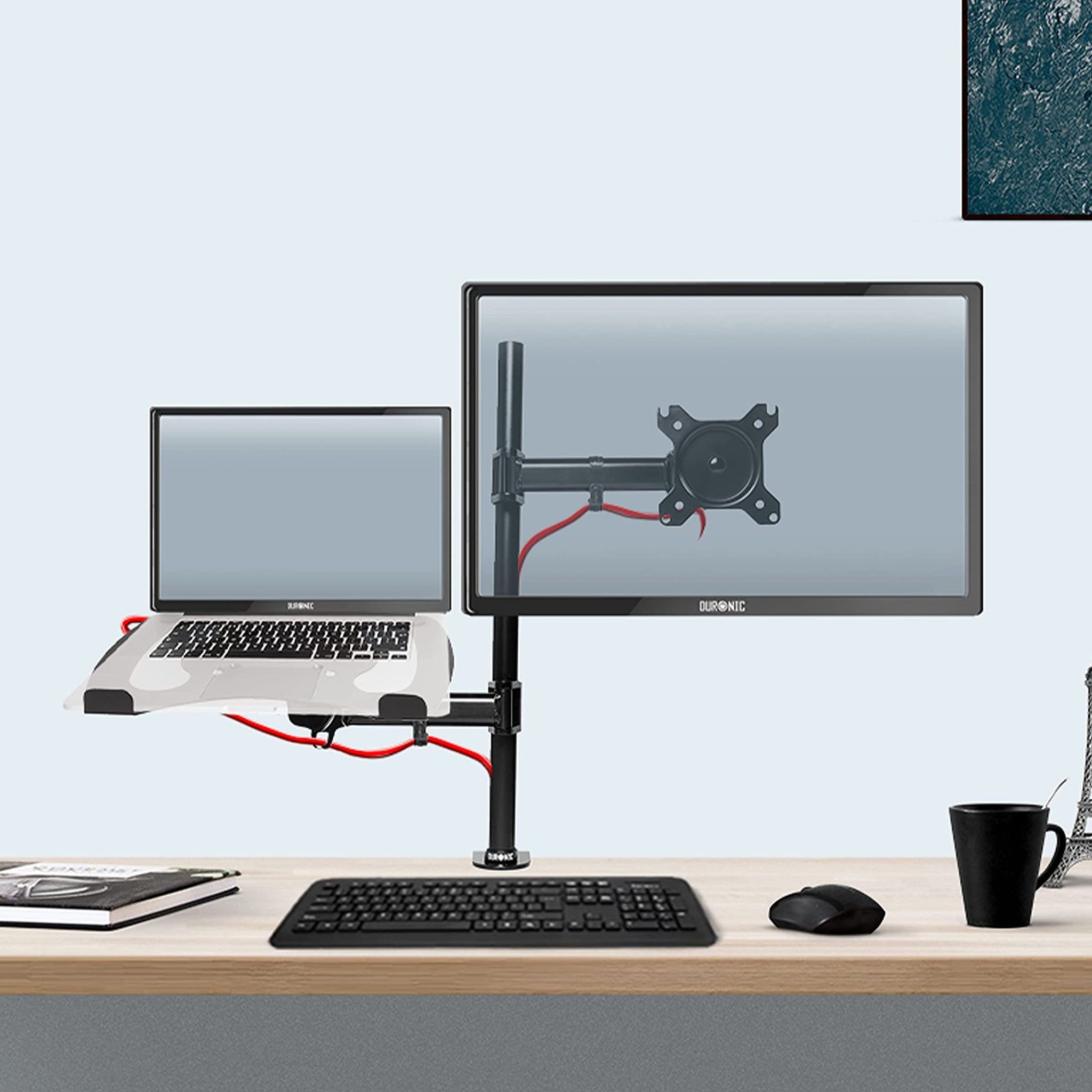 Configuración de escritorio con monitores duales, uno con soporte para portátil, teclado, ratón y taza.