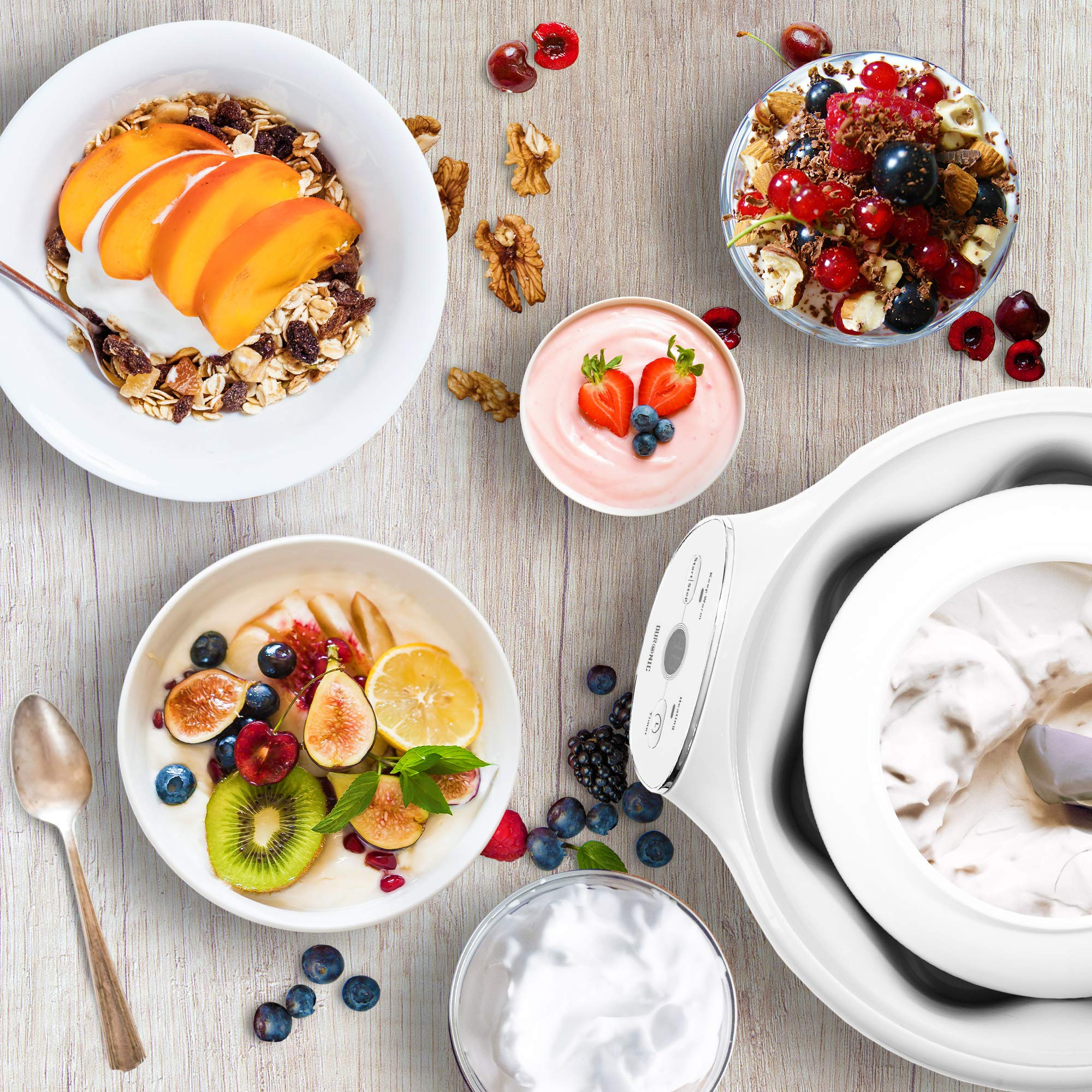 Draufsicht auf Schalen mit Joghurt und Obst, Müsli und eine weiße Eismaschine.