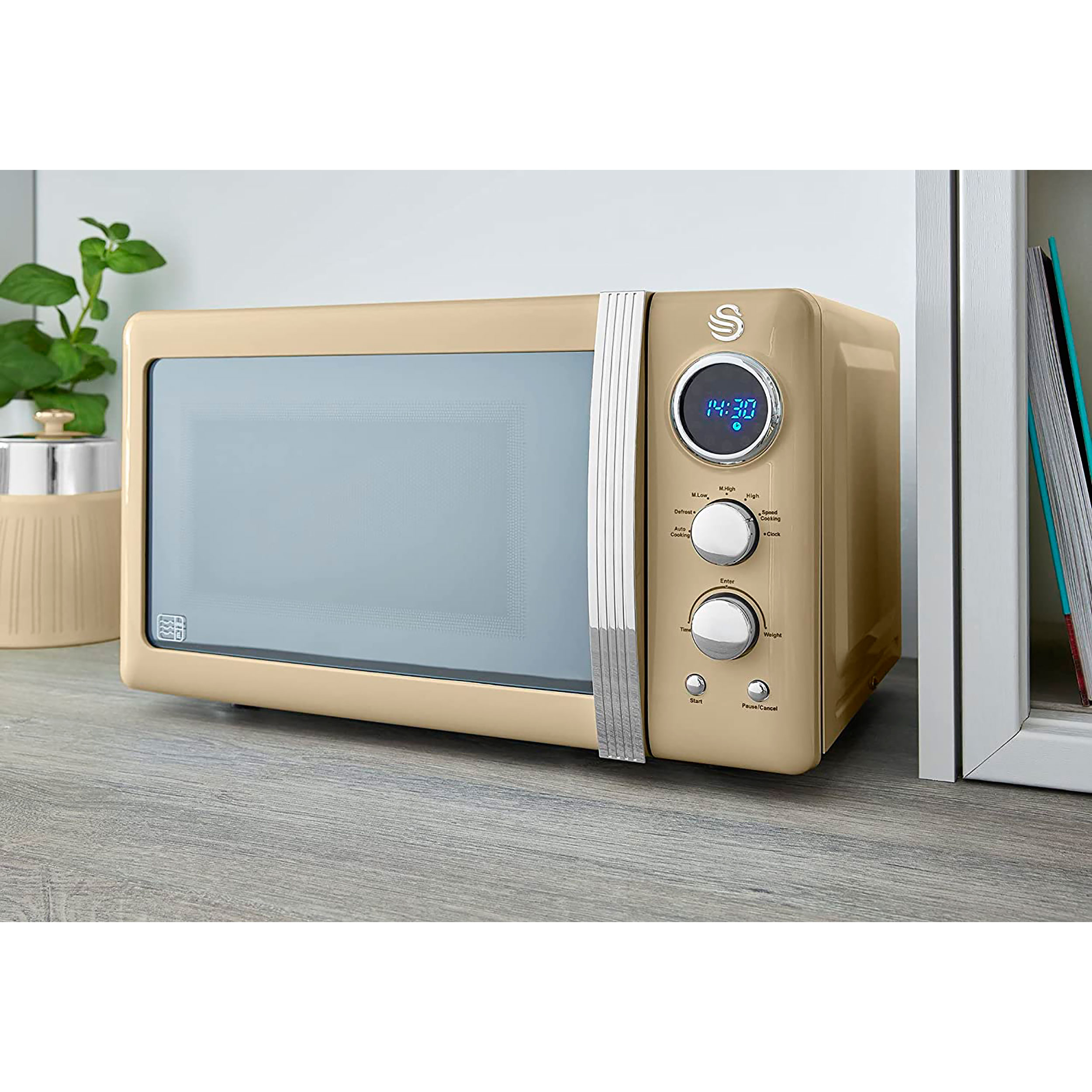 Horno microondas beige con botones, pantalla y una planta.