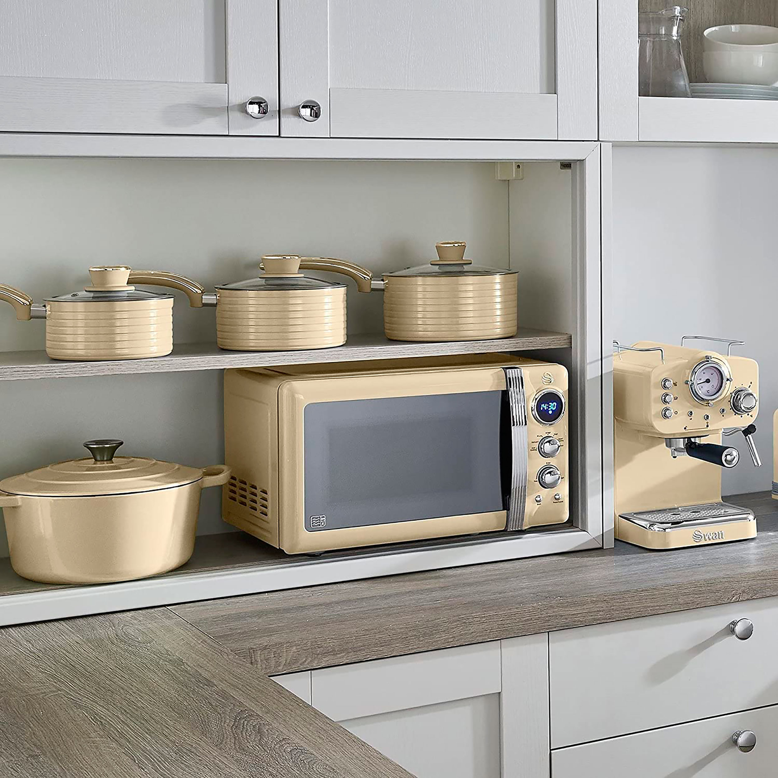 Una escena de cocina con electrodomésticos color crema, incluyendo un microondas y una cafetera.