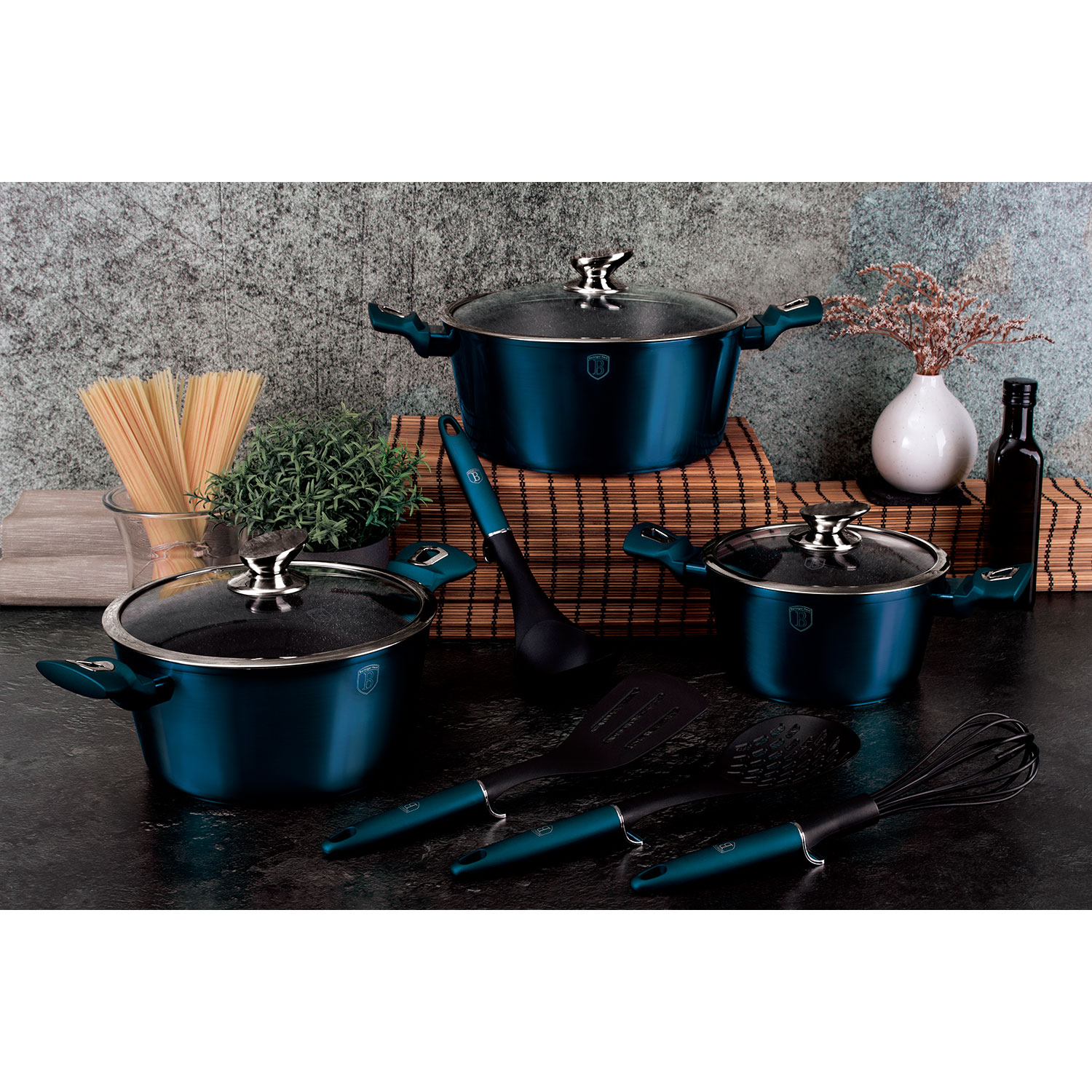 Escena de cocina con ollas azules, utensilios y un jarrón de flores sobre una superficie oscura.