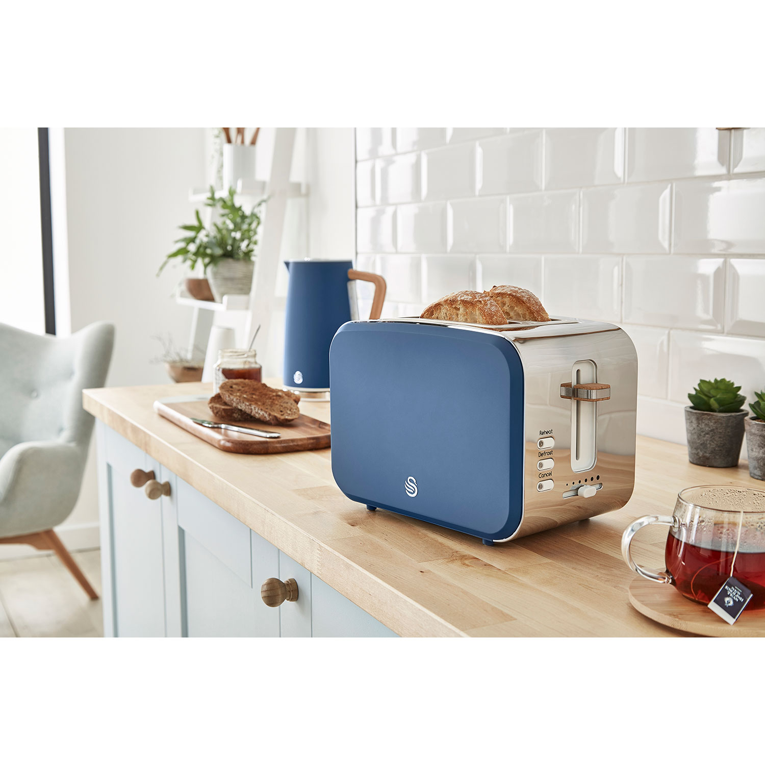 Toaster mit Brot. Blaues und silbernes Design. Küchenumgebung im Hintergrund.