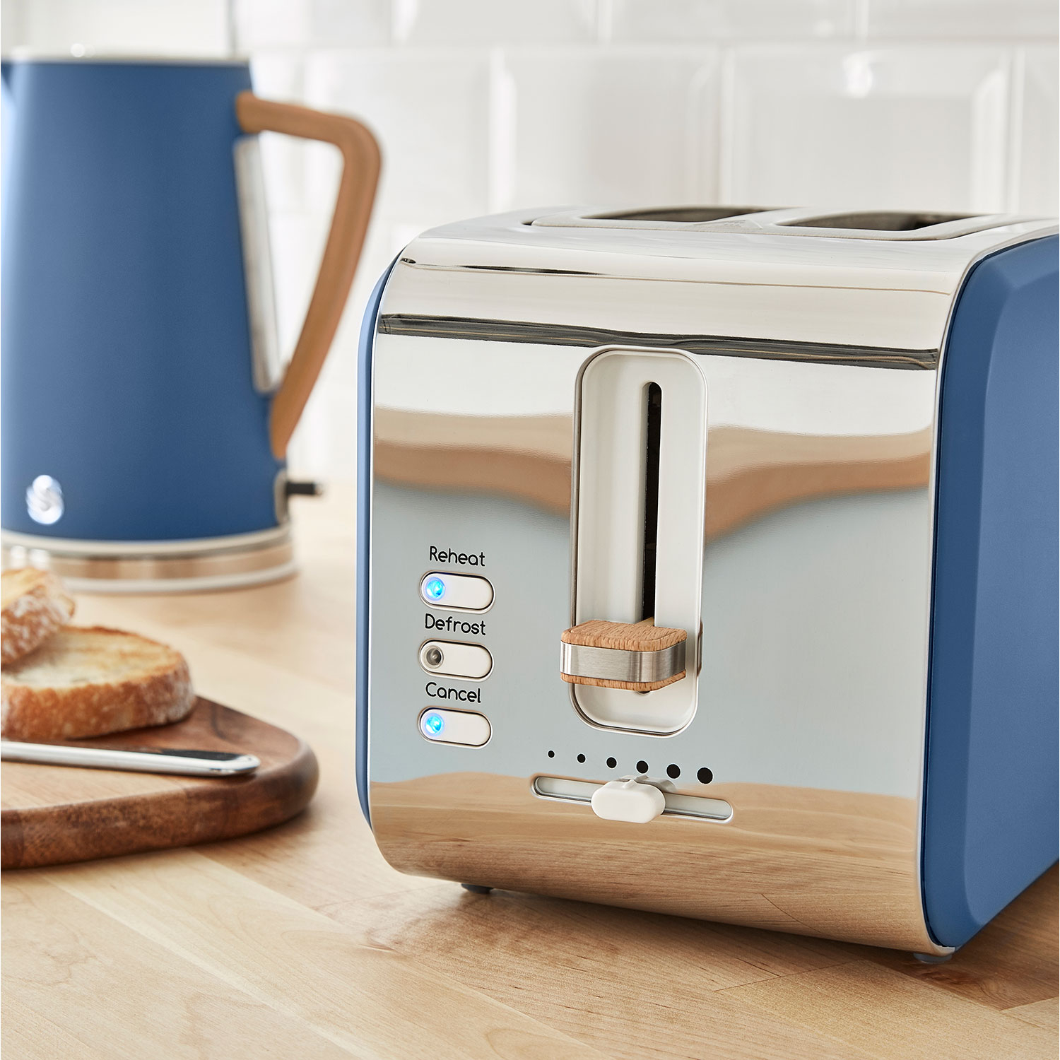 Ein blauer und silberner Toaster mit Brot und einem Wasserkocher.