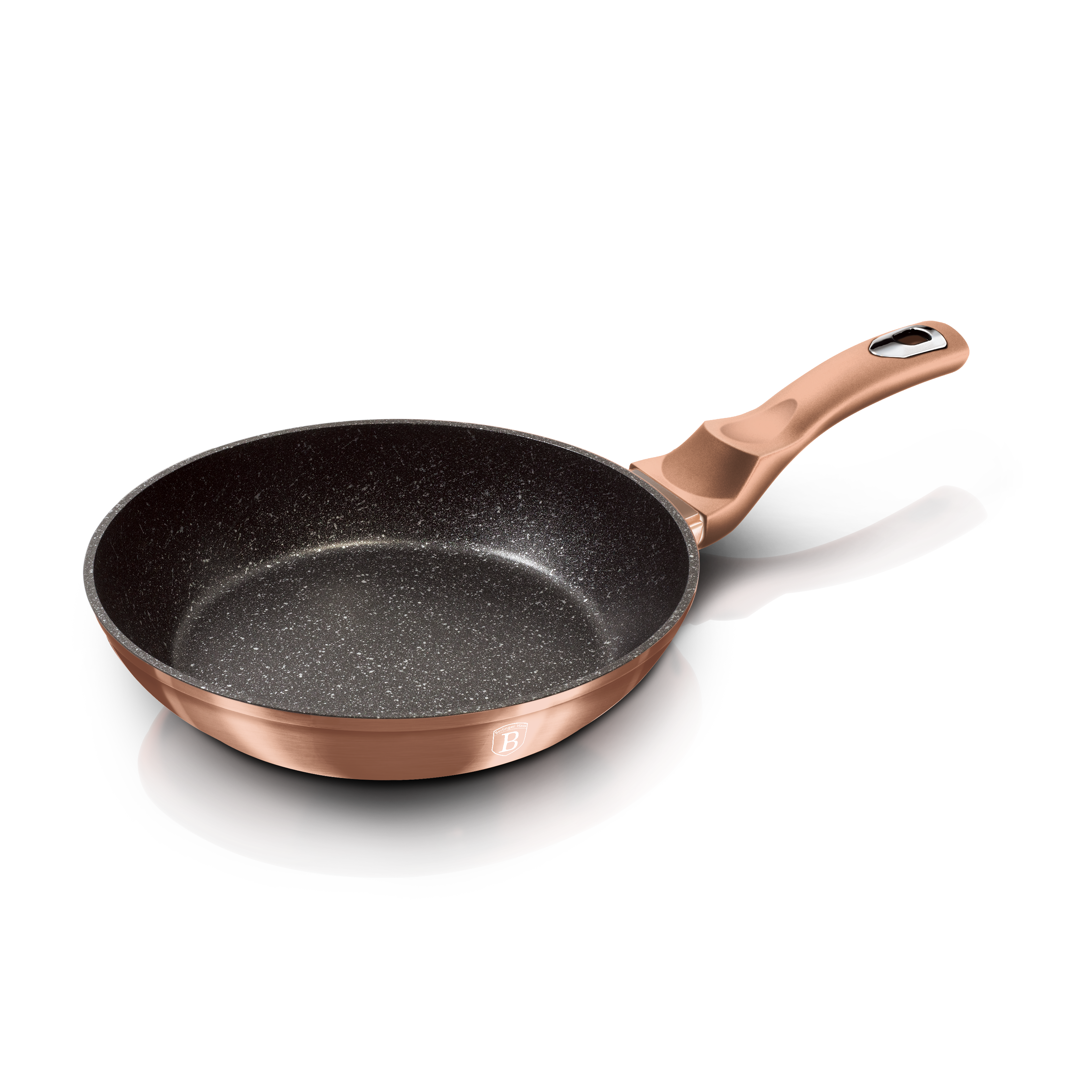 Una sartén de oro rosa con interior negro, sobre un fondo negro. Mango a la derecha.