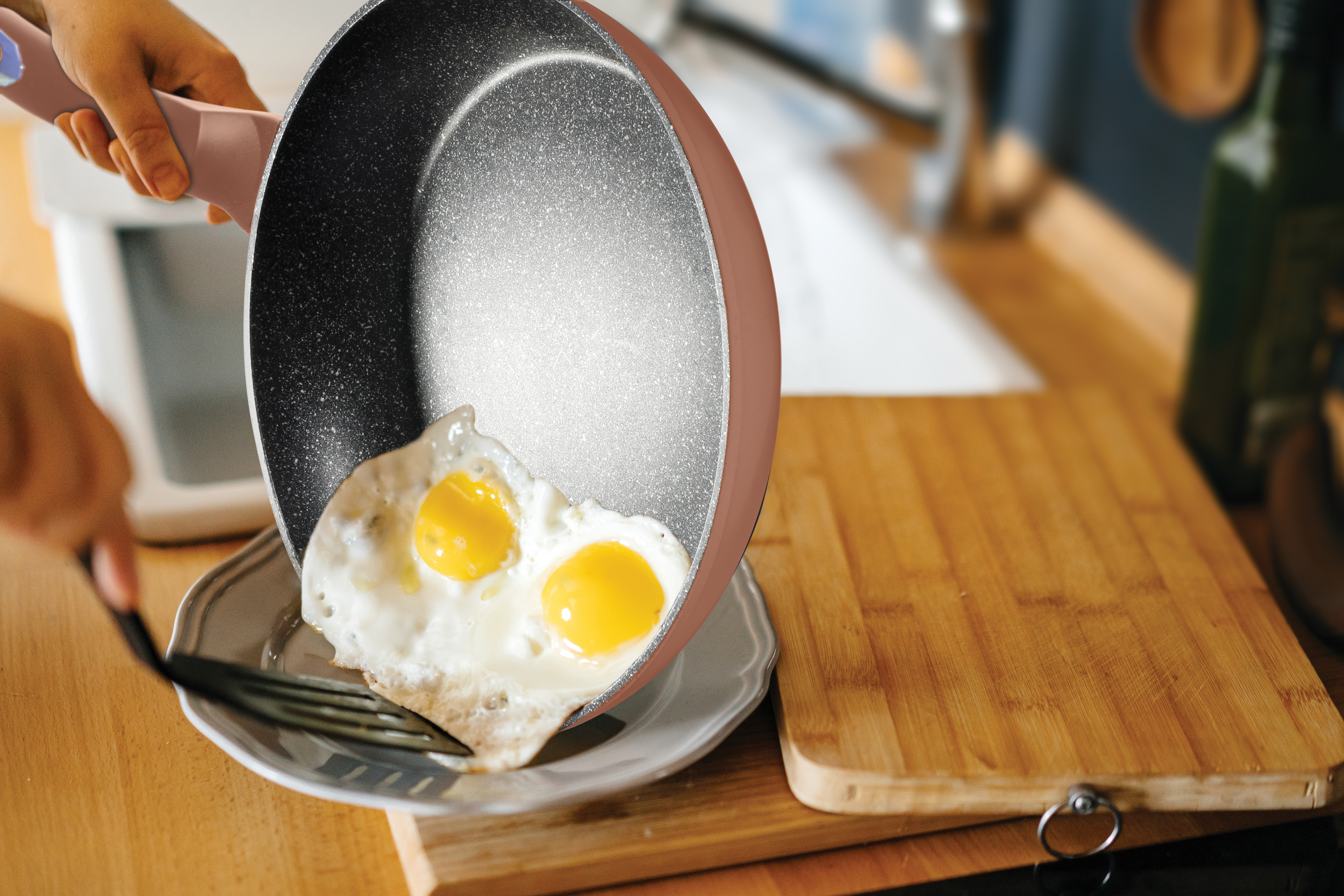 Huevos que se colocan en un plato desde una sartén. Se sirven dos huevos fritos.