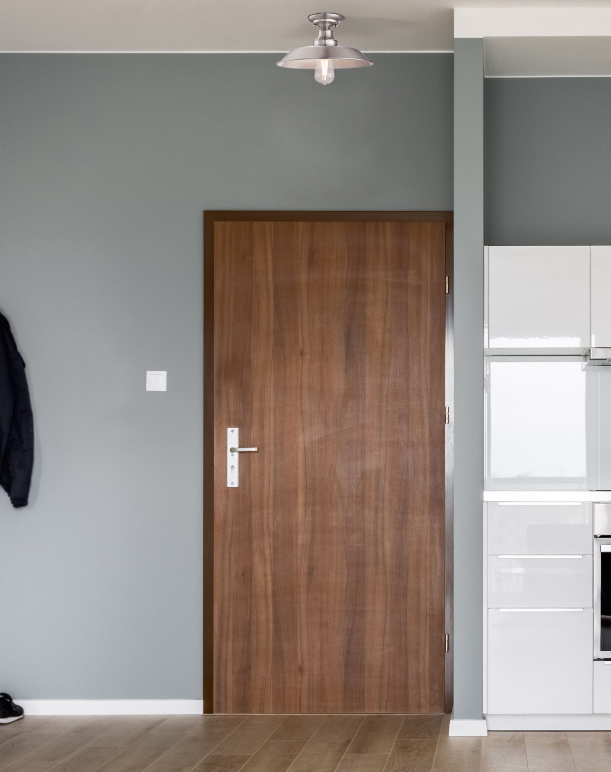 Ein Raum mit Holztür, grauen Wänden und Deckenleuchte.