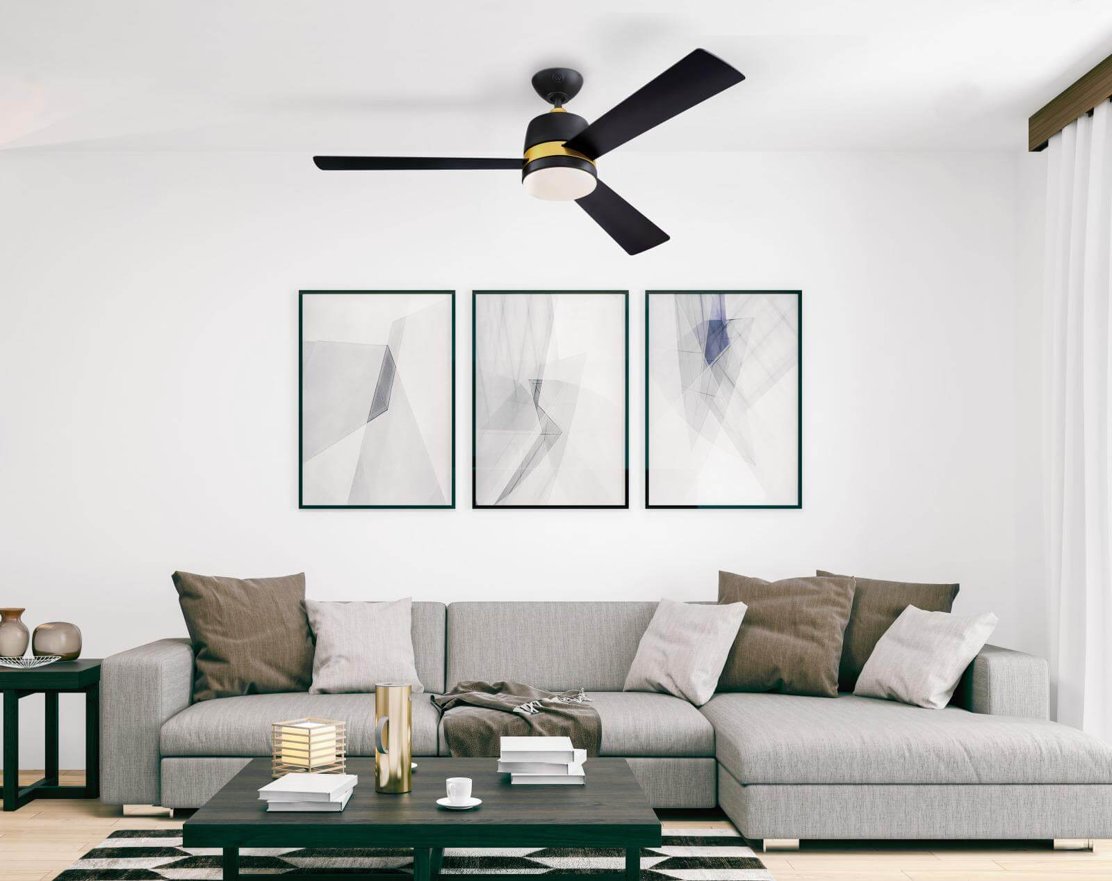 Soggiorno con divano grigio, tre opere d'arte astratte e un ventilatore da soffitto nero.