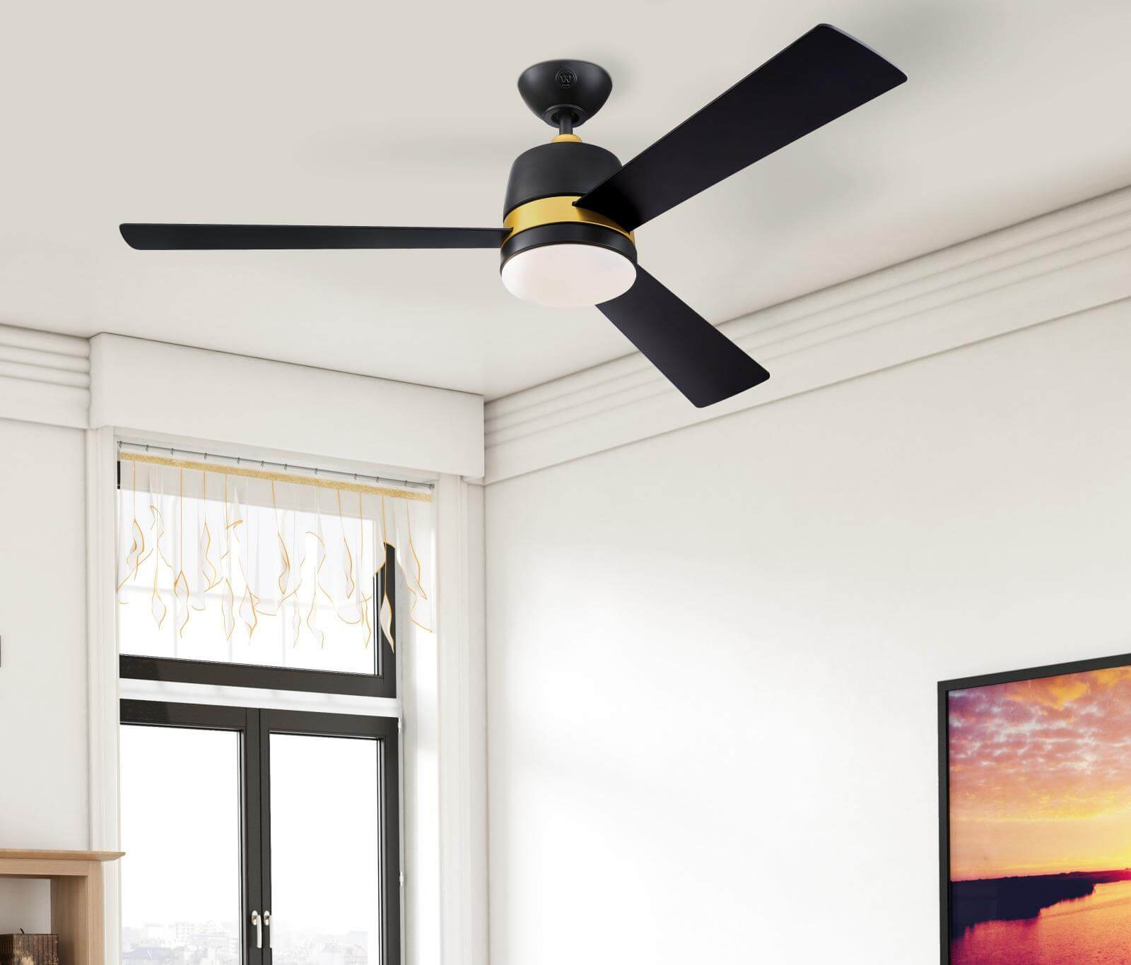 Un ventilatore a soffitto con tre pale nere, un alloggiamento motore nero e oro e una luce bianca.