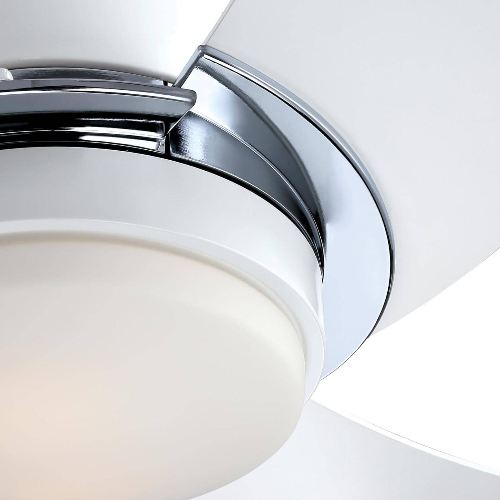 Nahaufnahme eines weißen Deckenventilators mit Chromakzent und Leuchte.