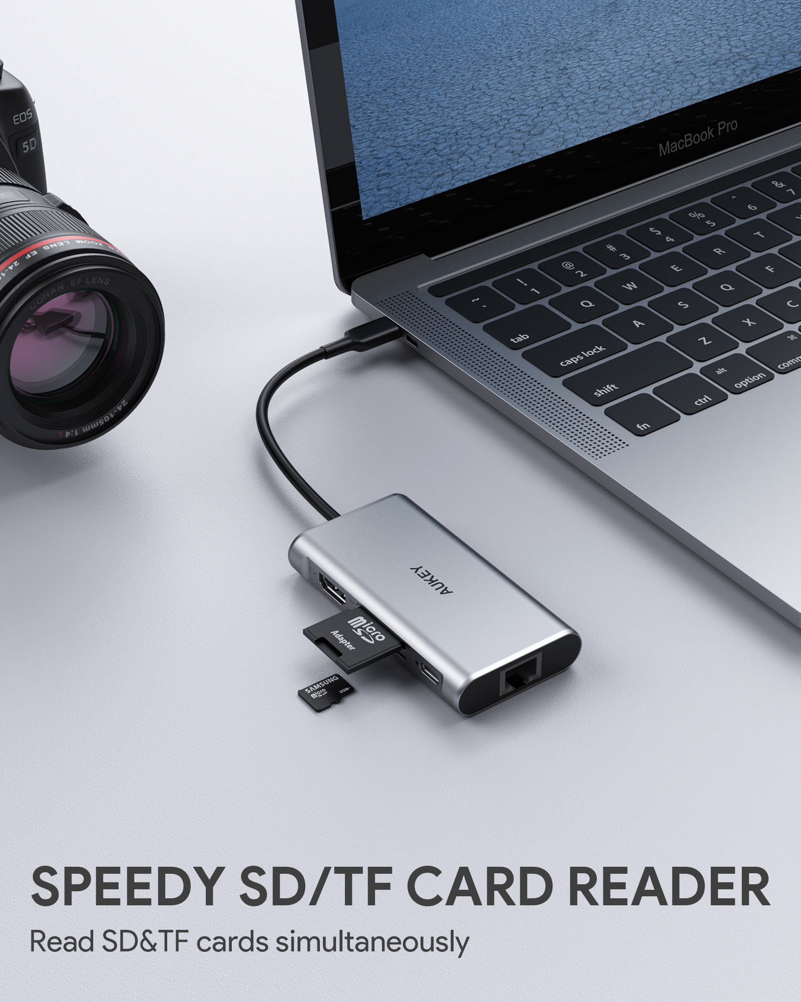 Ein silberner Hub mit einem USB-Kabel, das an einem Laptop angeschlossen ist. Eine Karte und ein Laufwerk sind eingesetzt.
