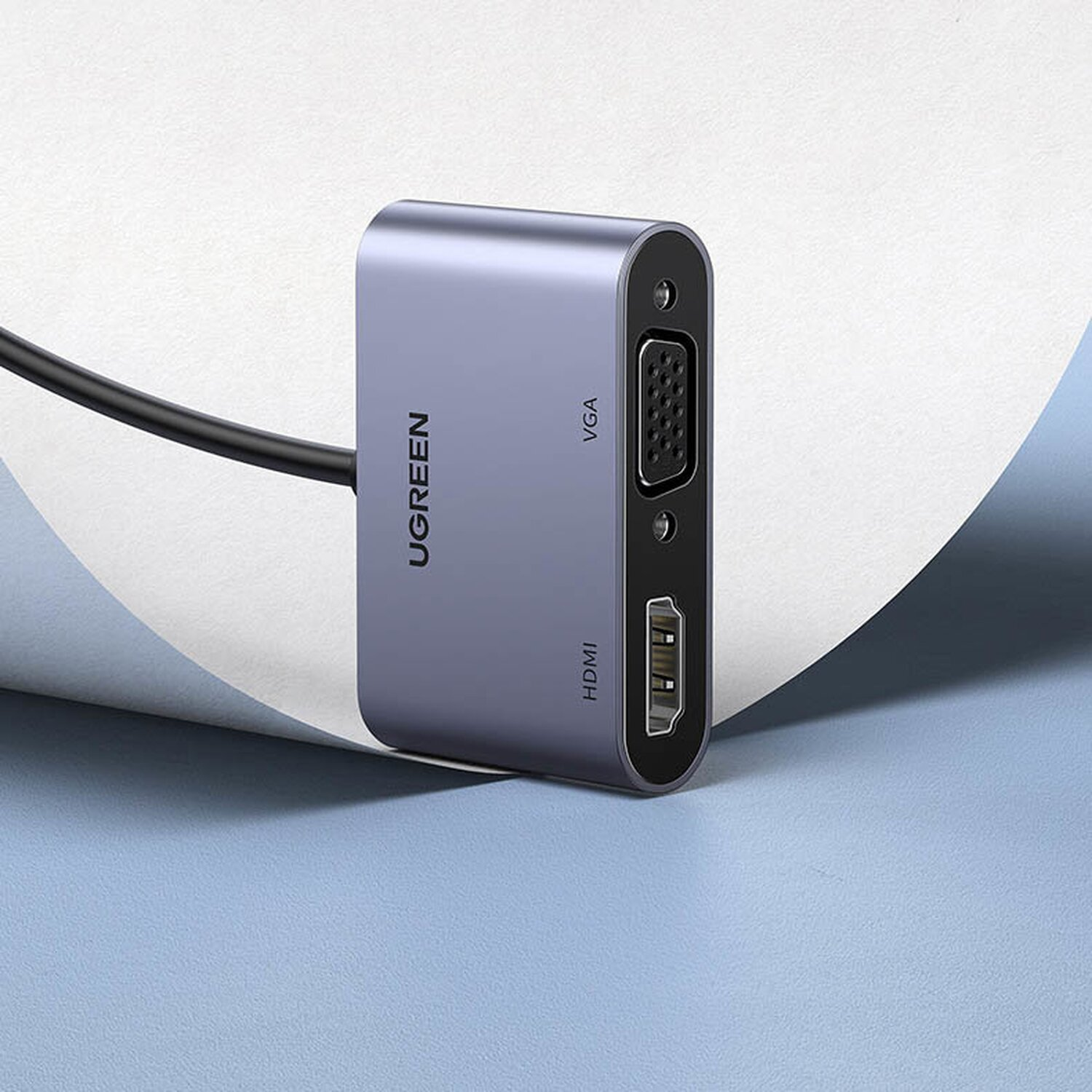 Blau-grauer UGREEN HDMI-zu-VGA-Adapter, mit schwarzem Kabel, auf Oberfläche.