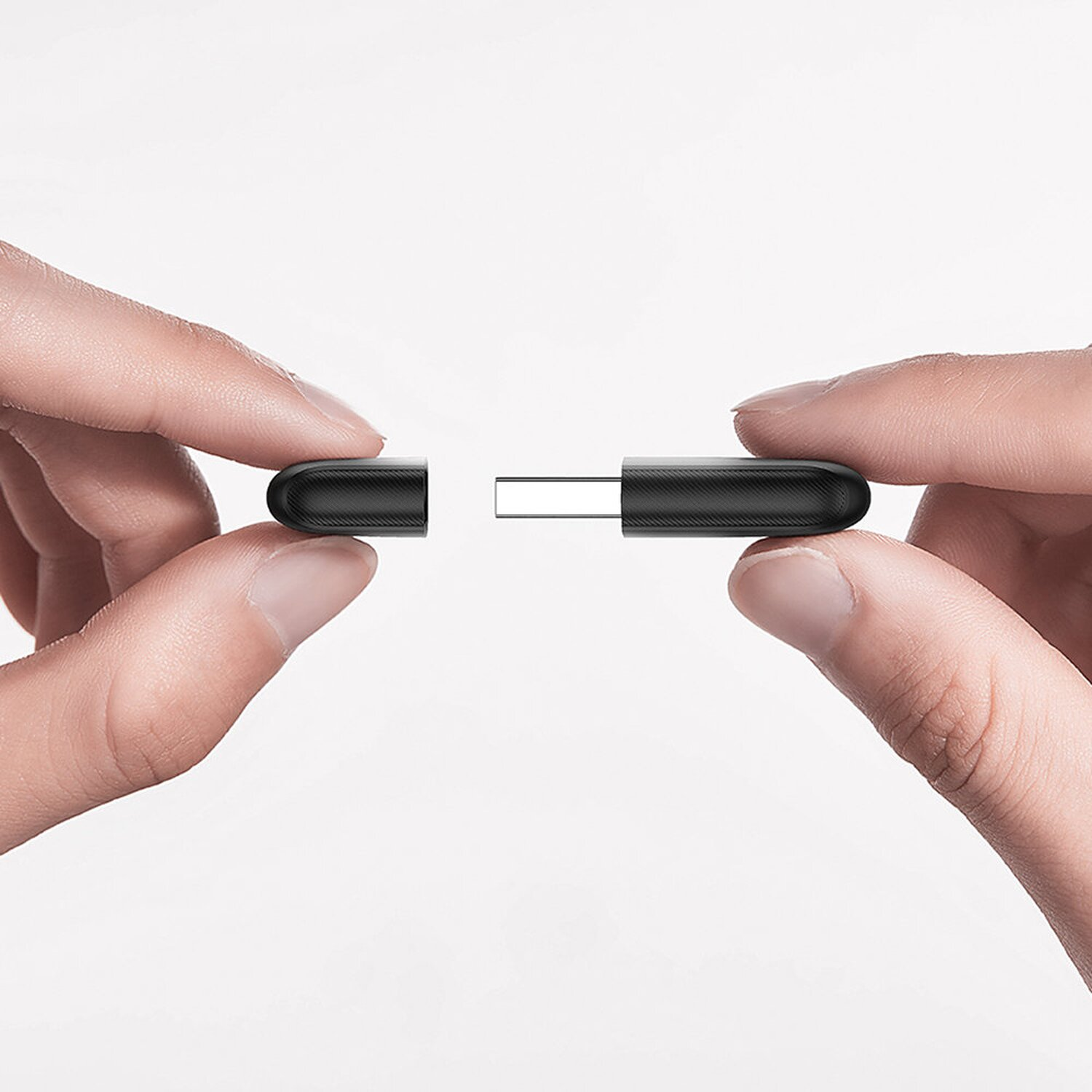 Dwie ręce trzymające napęd USB, napęd USB jest otwarty i podzielony.