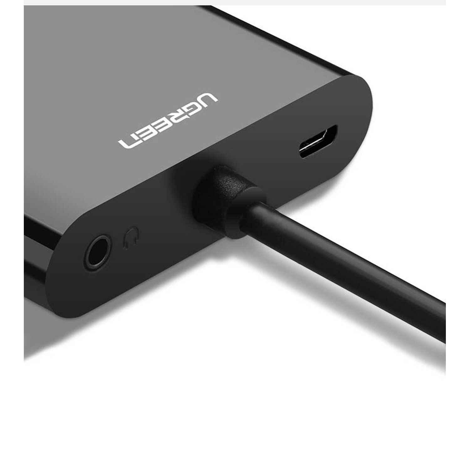 Schwarzer UGREEN-Adapter. Er hat einen USB-C-Anschluss, einen Kopfhöreranschluss und ein schwarzes Kabel.
