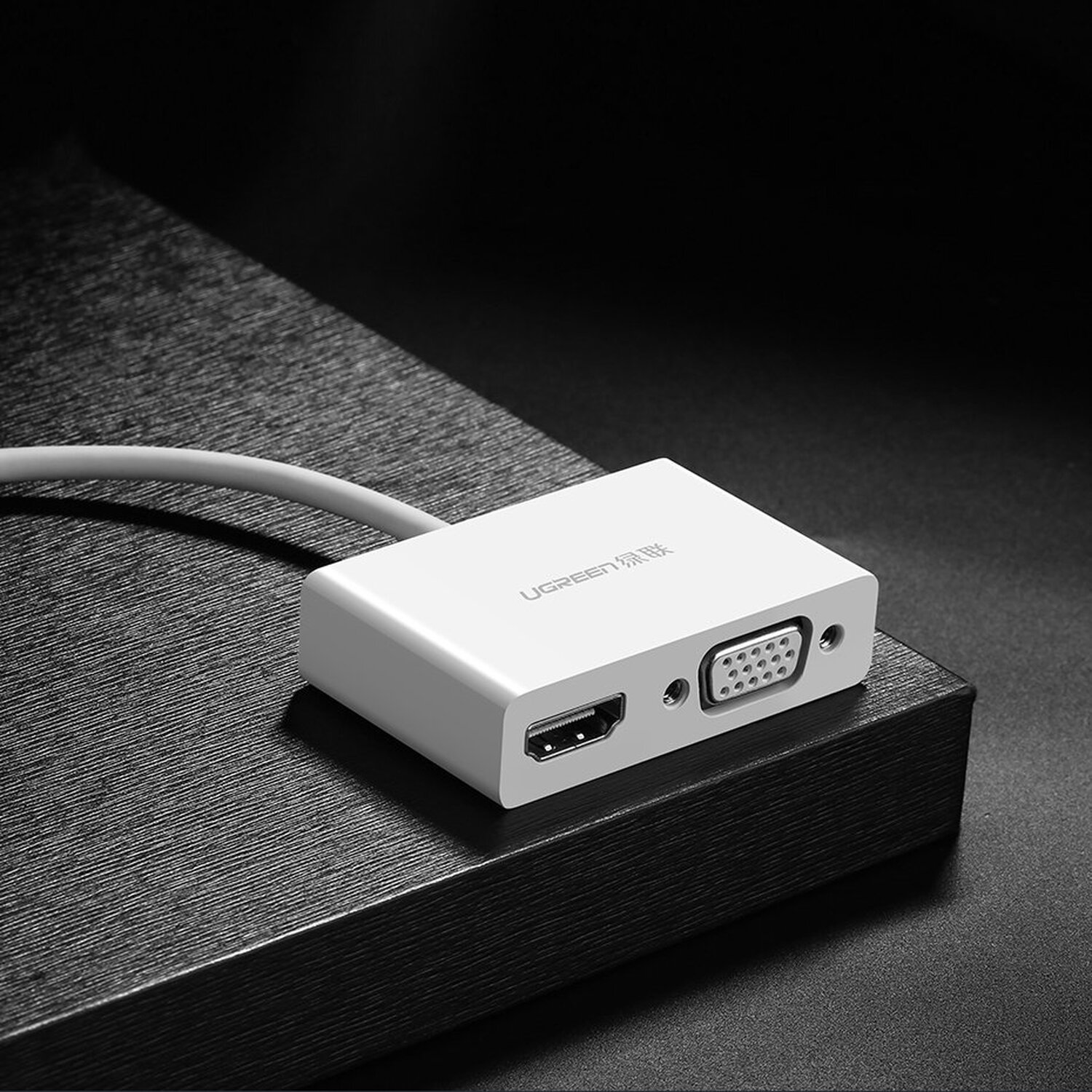 Weißer Adapter mit HDMI- und VGA-Anschlüssen und dem UGREEN-Logo. Dunkler Hintergrund.