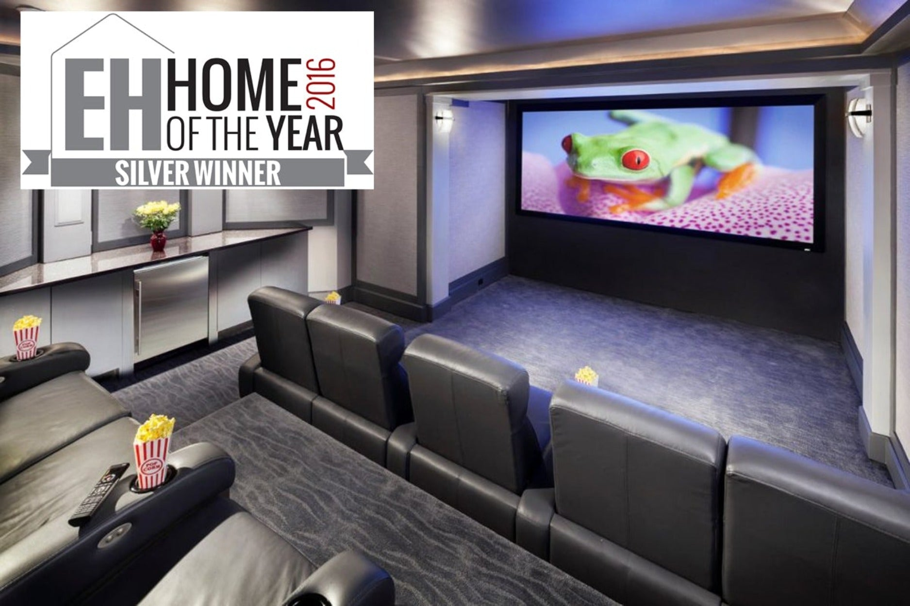 Home cinema con schermo a rana, sedili e popcorn.