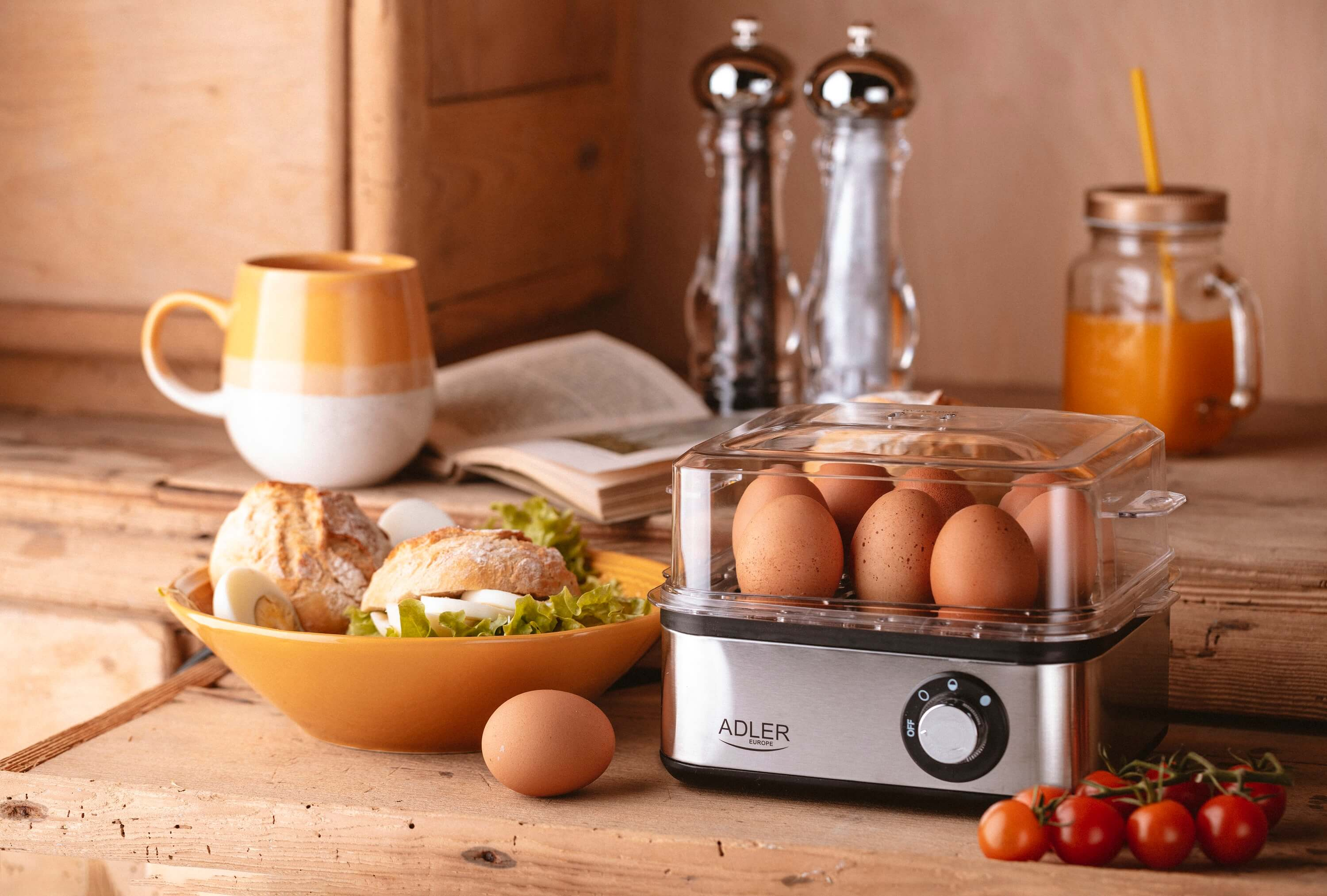 Scena śniadaniowa: jajka w misce, jajowar, chleb, sok i sól i pieprz. Drewniane tło.