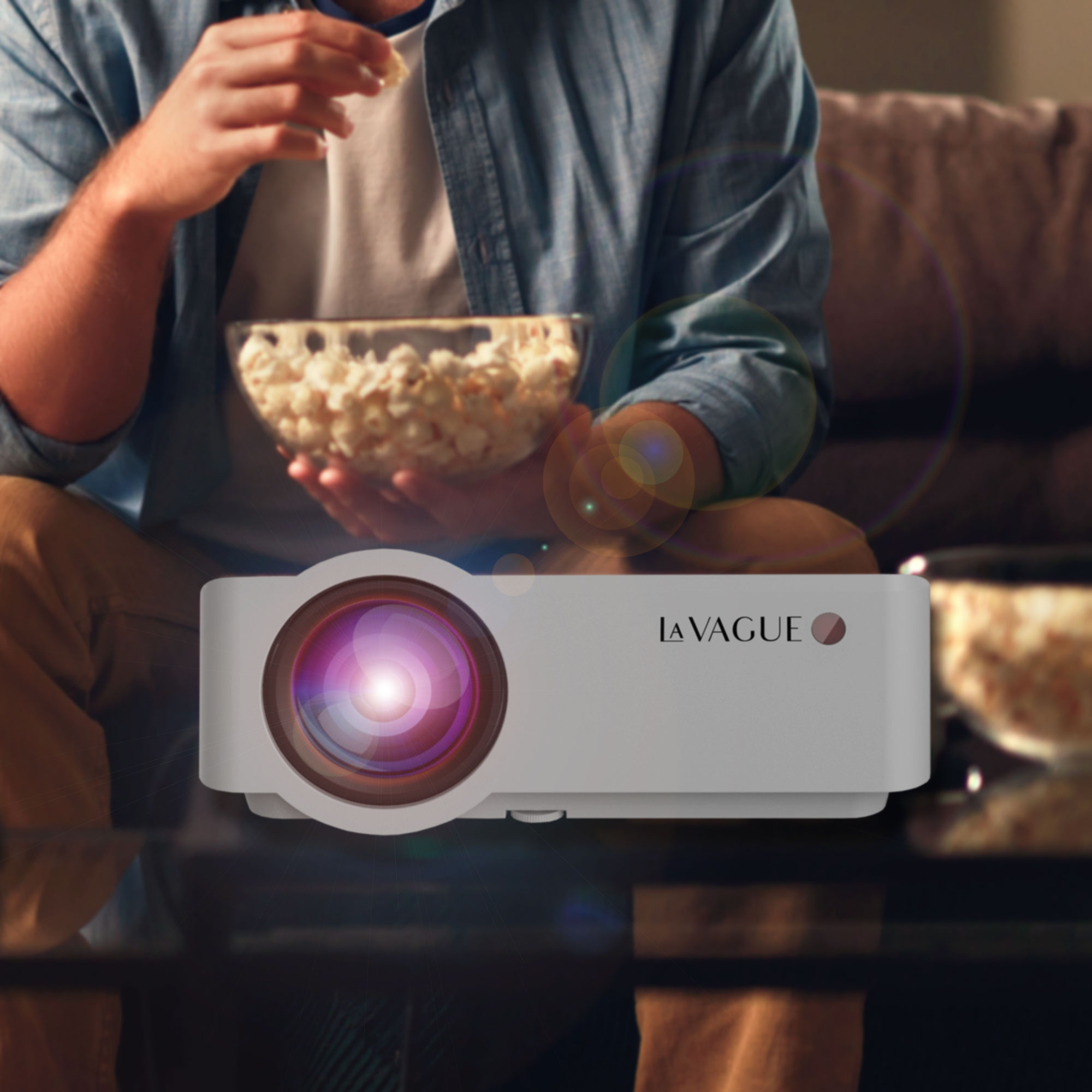 Ein Projektor, der eine Filmszene zeigt. Eine Person hält im Hintergrund Popcorn.