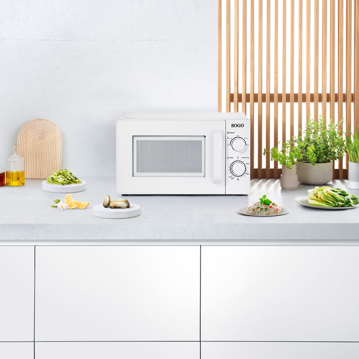 Horno microondas blanco sobre una encimera, con comida y decoraciones. El fondo es una cocina.
