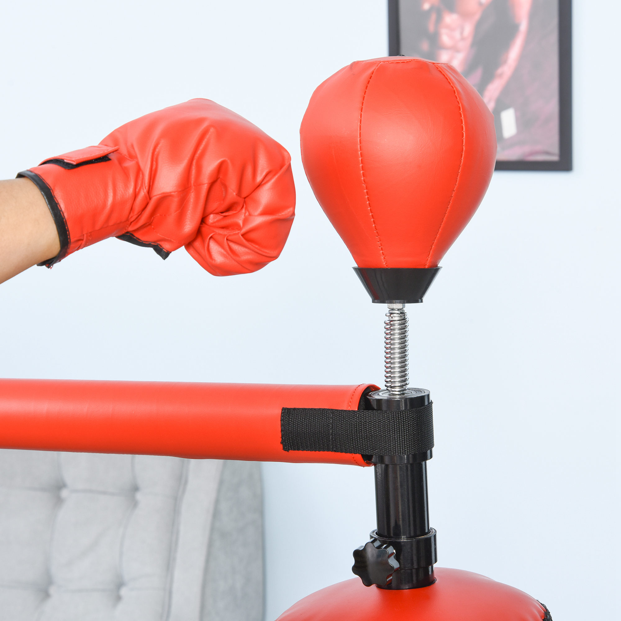 Mano con guante de boxeo rojo golpeando un saco de boxeo rojo.