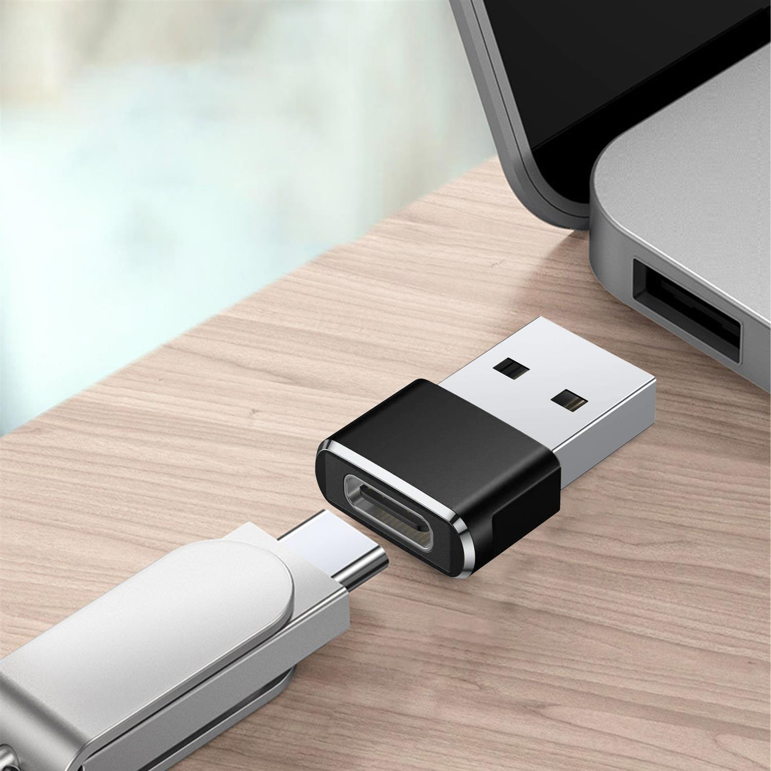 Adaptador USB a USB-C sobre una superficie de madera, conectado a un dispositivo USB-C.
